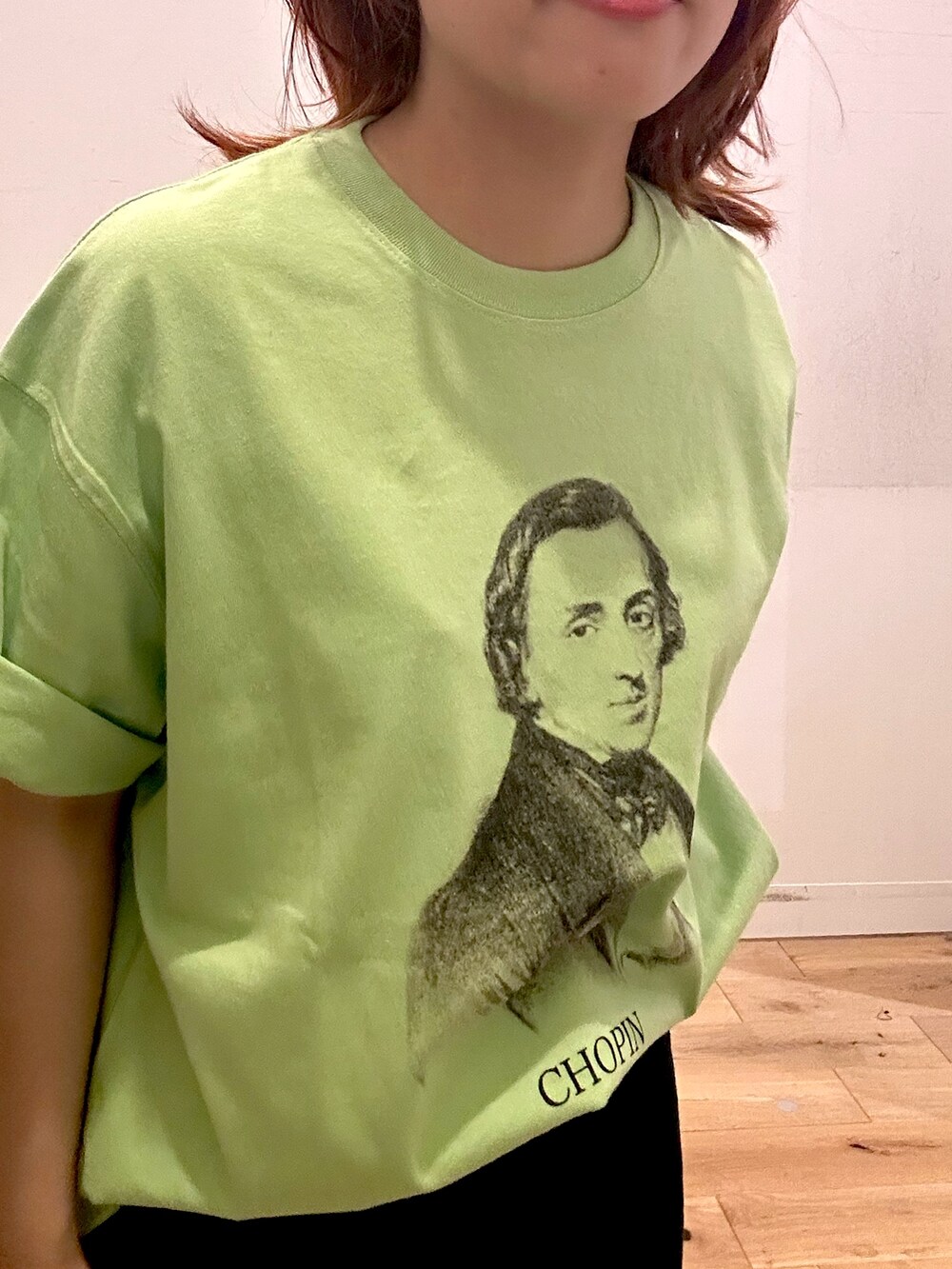 グリーン系のTシャツ/カットソー、ブラック系のスカートを着用したレディースの夏コーディネートの2枚目の写真