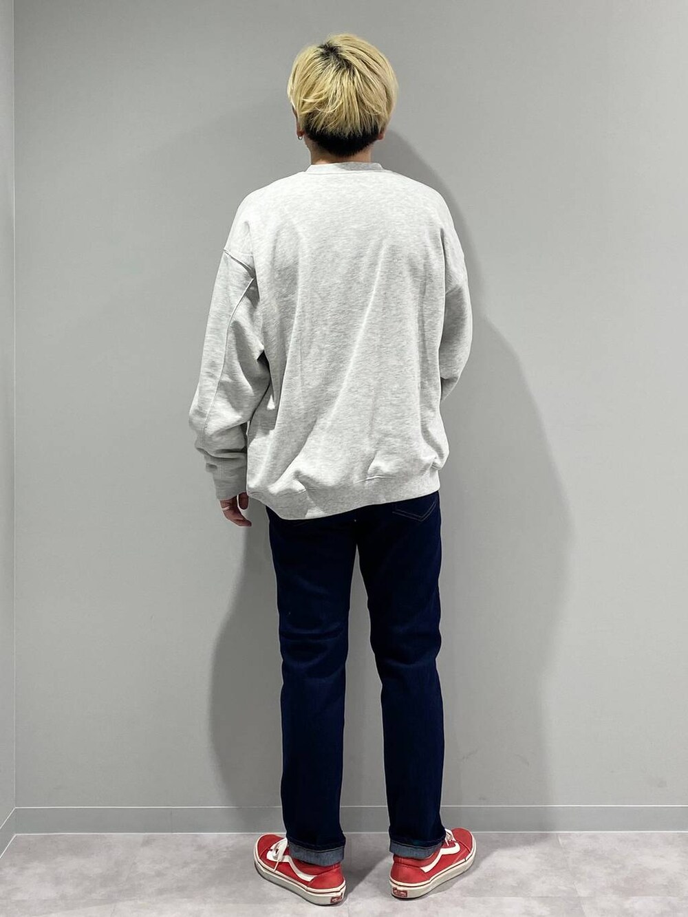 グレー系のスウェット、ブルー系のデニムパンツを着用したメンズの冬コーディネートの3枚目の写真