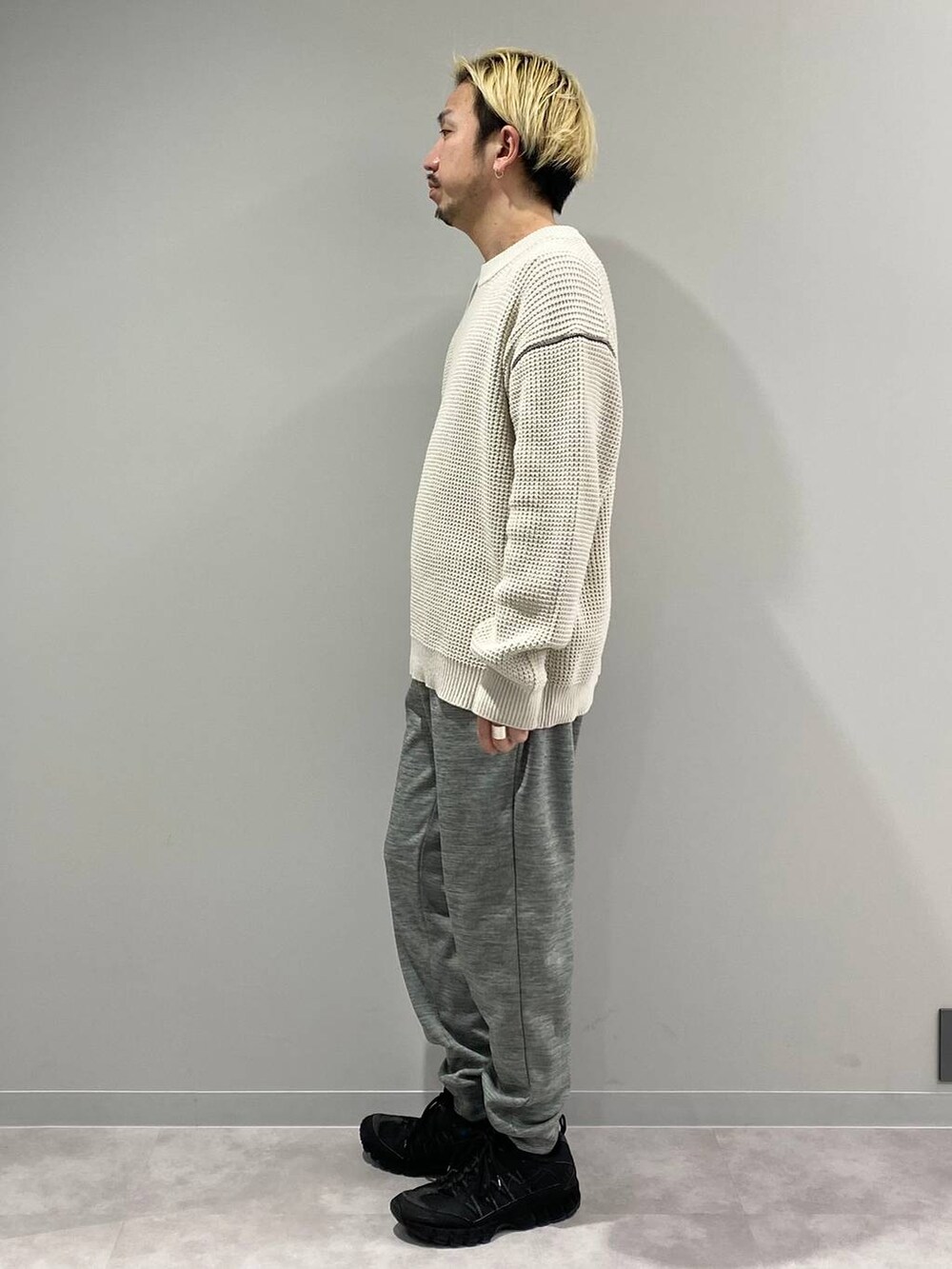 グレー系のその他パンツ、ホワイト系のニット/セーターを着用したメンズの冬コーディネートの2枚目の写真