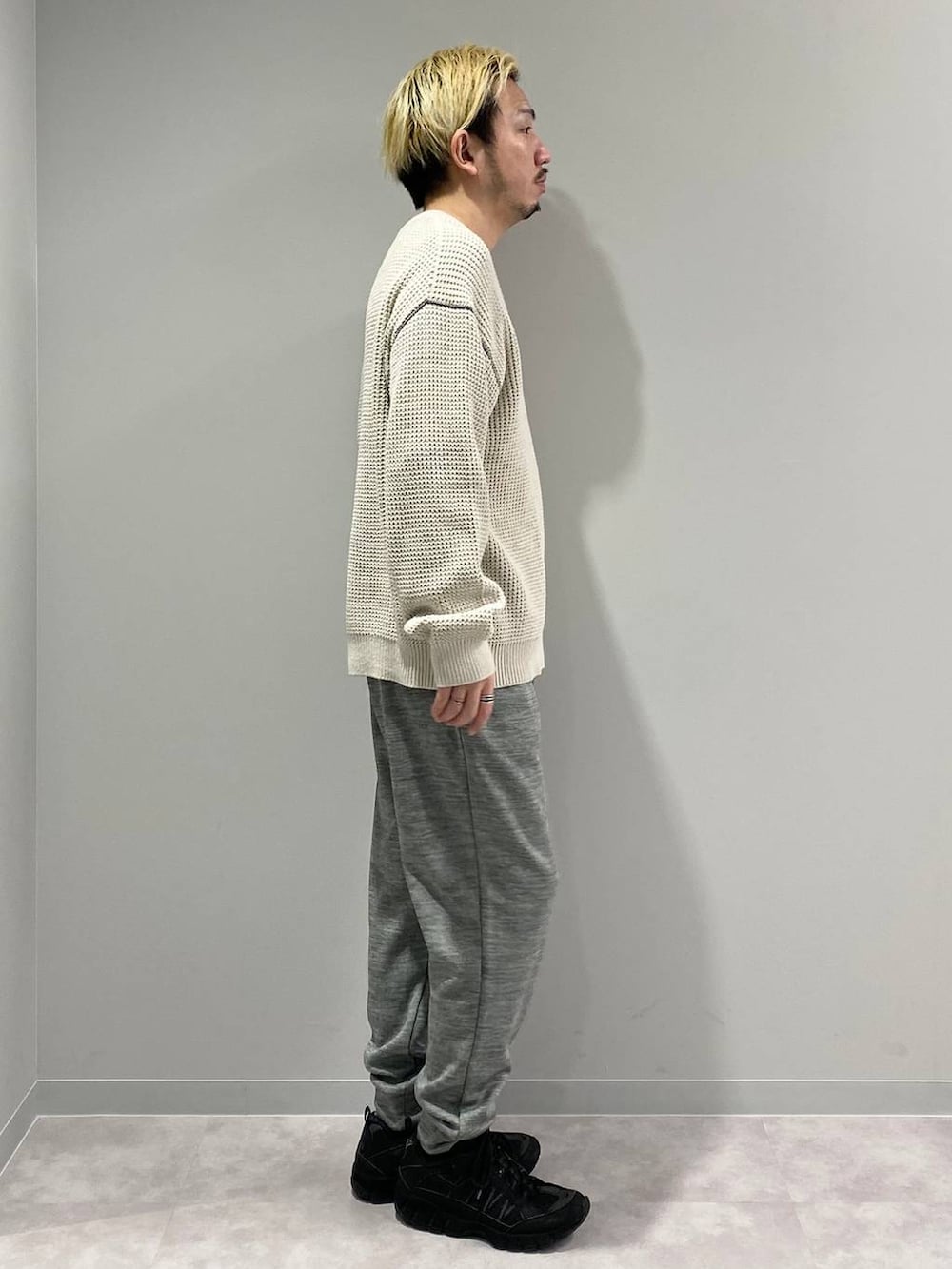 グレー系のその他パンツ、ホワイト系のニット/セーターを着用したメンズの冬コーディネートの4枚目の写真