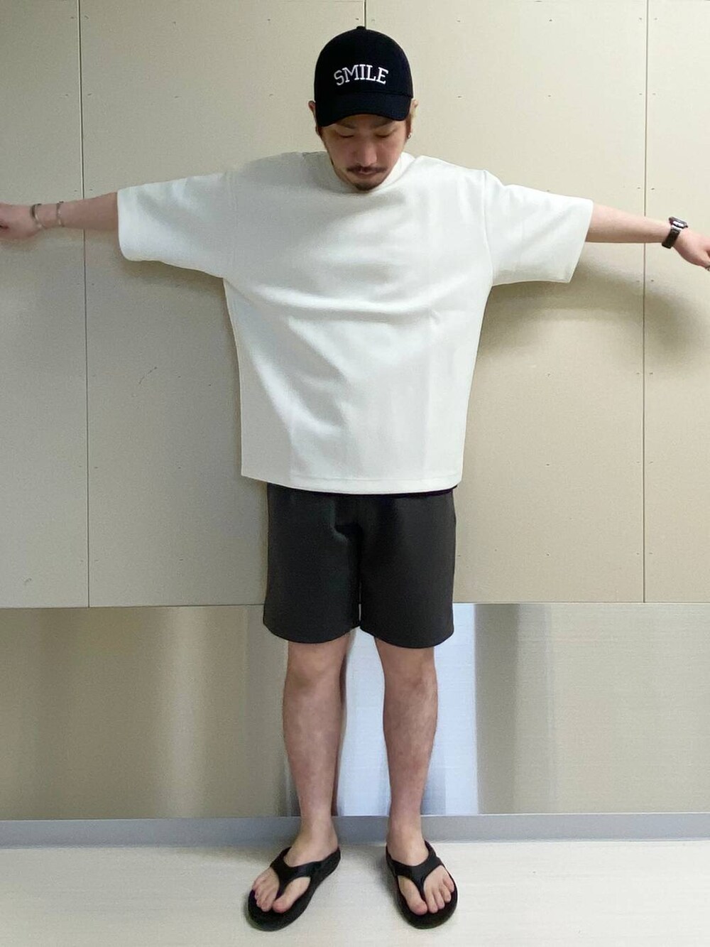 ホワイト系のTシャツ/カットソー、グレー系のスウェットパンツ、ブラック系のキャップを着用したメンズの夏コーディネートの4枚目の写真
