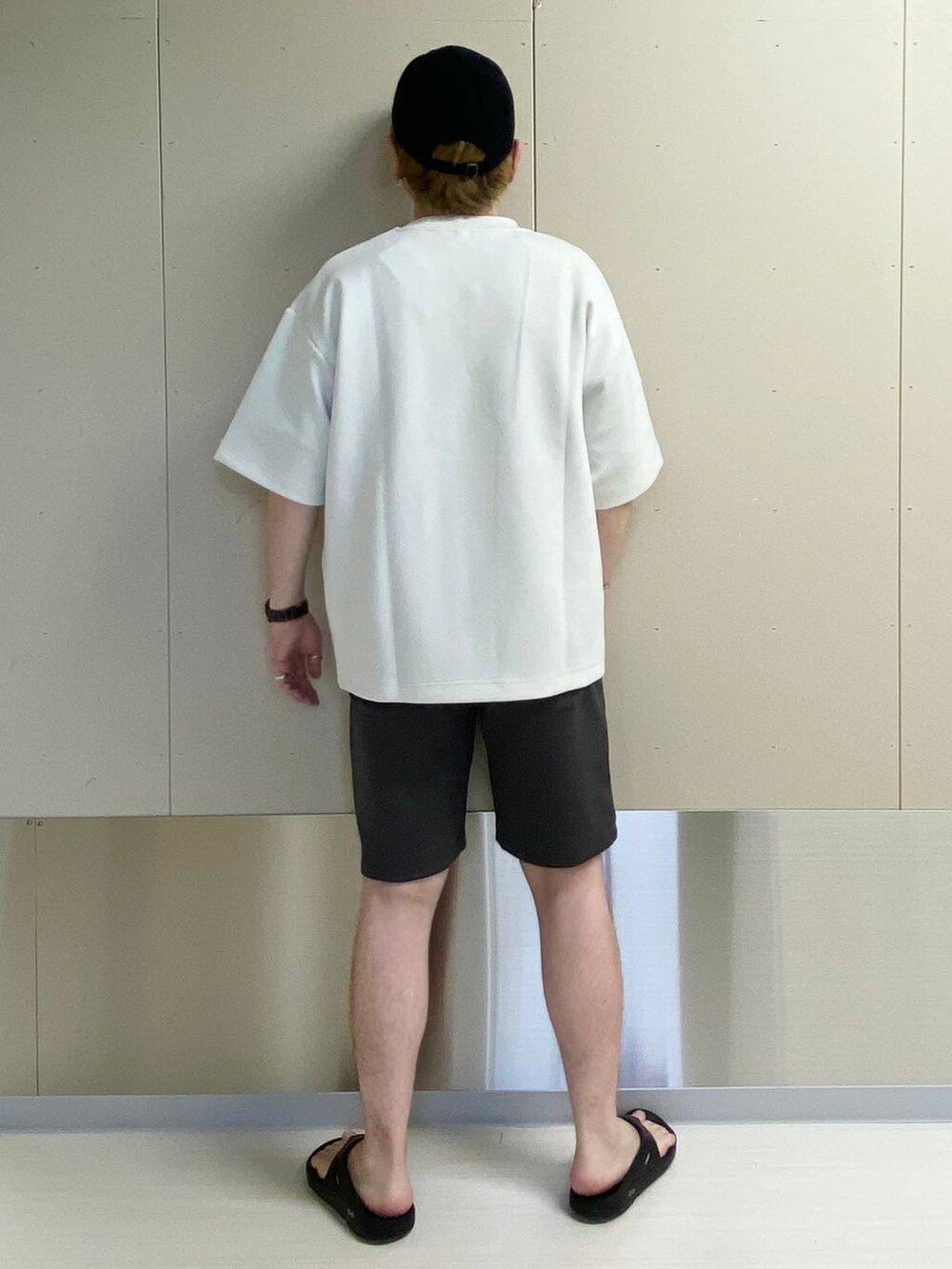 ホワイト系のTシャツ/カットソー、グレー系のスウェットパンツ、ブラック系のキャップを着用したメンズの夏コーディネートの2枚目の写真