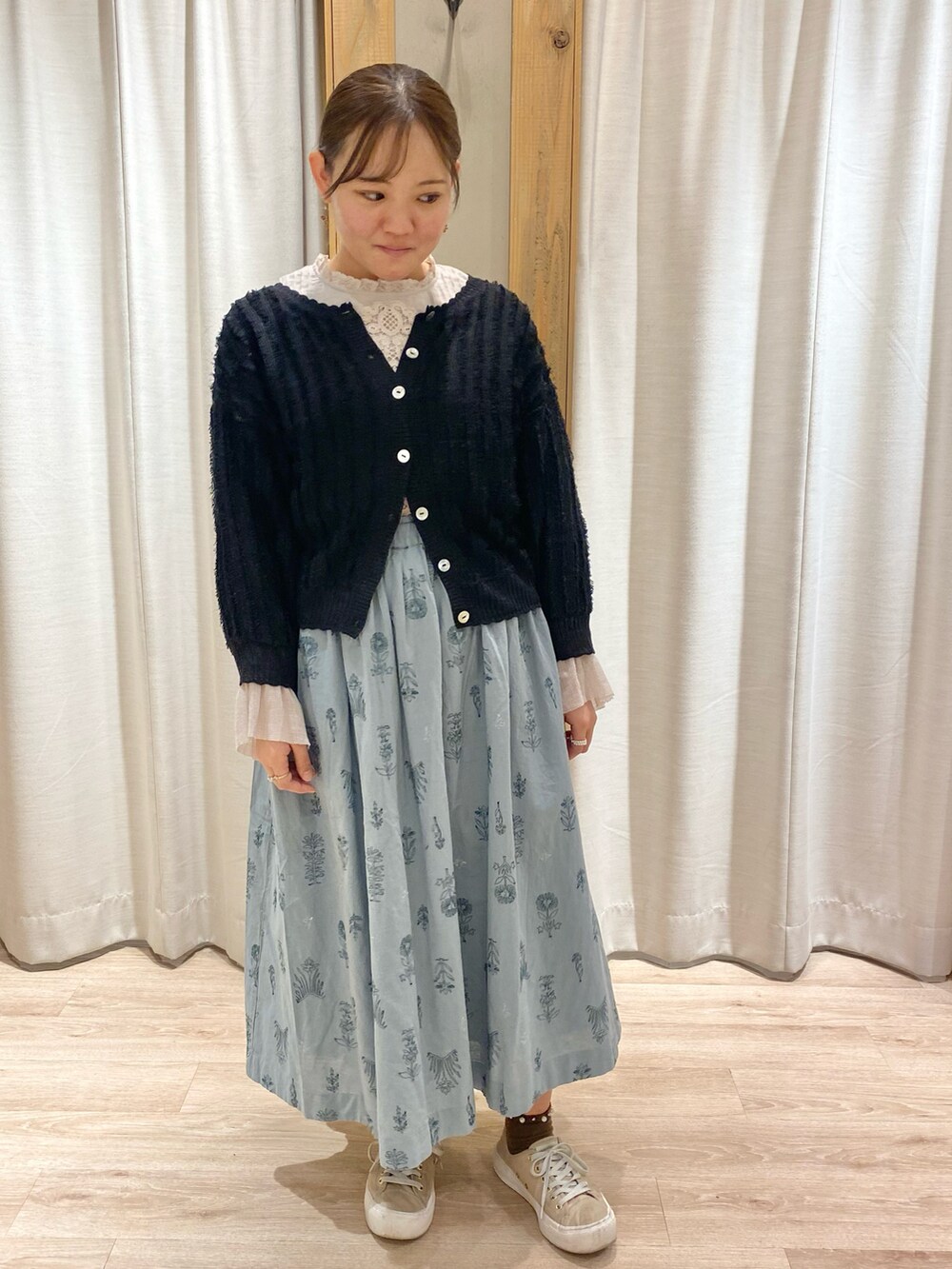 ブルー系のスカート、ベージュ系のシャツ/ブラウス、ブラック系のカーディガン/ボレロを着用したレディースの春コーディネートの2枚目の写真