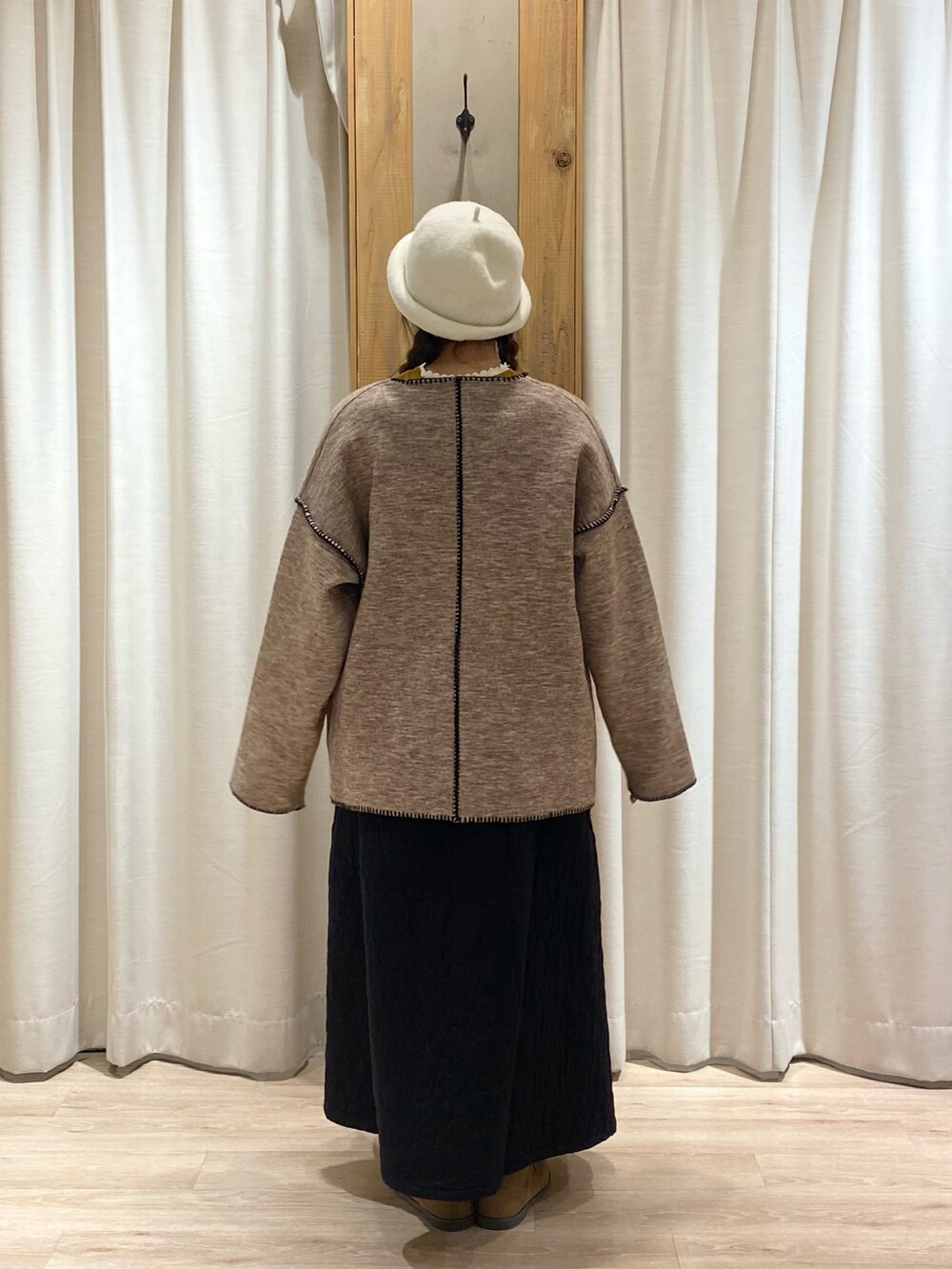 ベージュ系のノーカラージャケットを着用したレディースの冬コーディネートの5枚目の写真