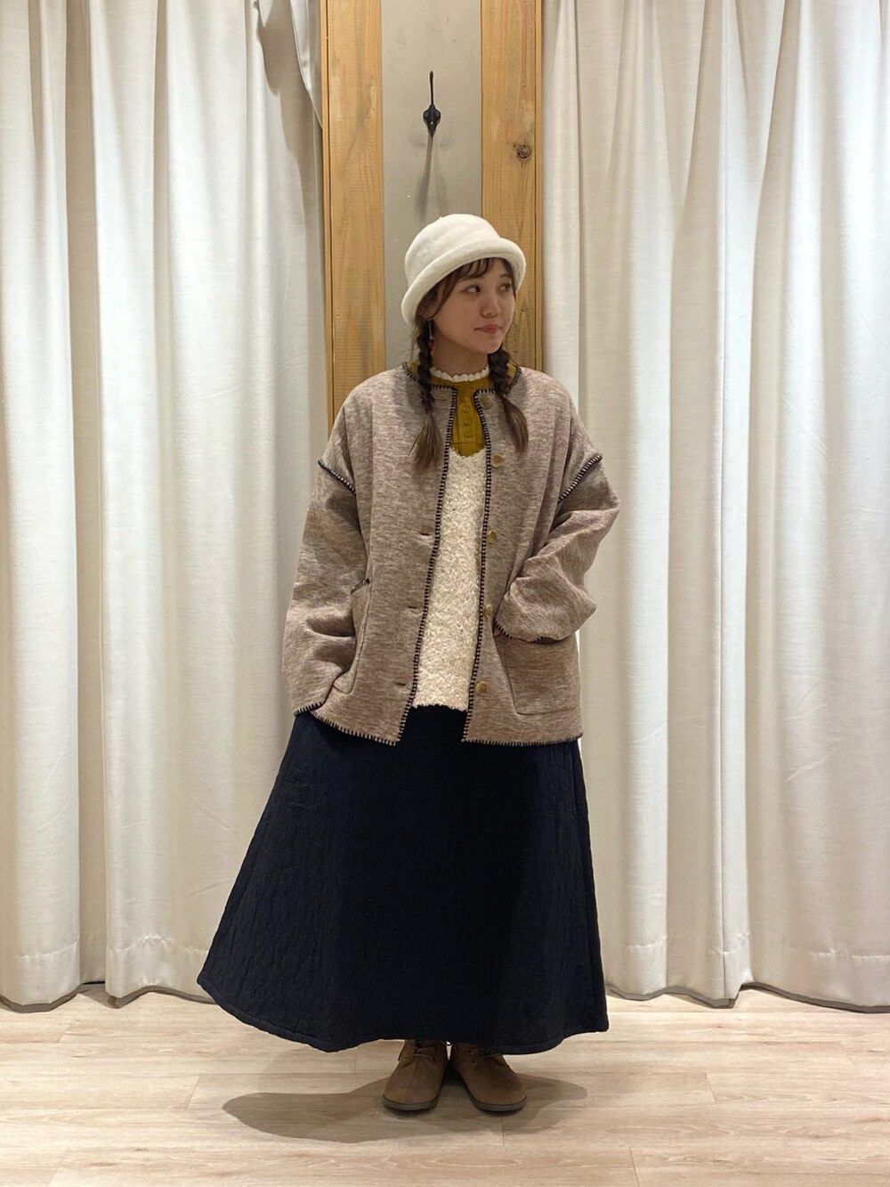 ベージュ系のノーカラージャケットを着用したレディースの冬コーディネートの2枚目の写真