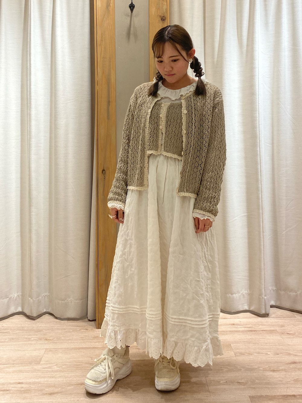 ブラウン系のカーディガン/ボレロ、ブラウン系のベスト、ホワイト系のTシャツ/カットソーを着用したレディースの春コーディネートの2枚目の写真