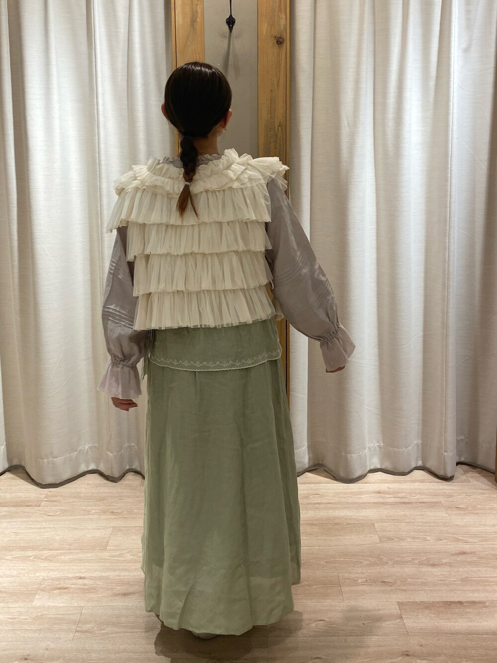 ベージュ系のシャツ/ブラウス、ホワイト系のベスト、グリーン系のスカートを着用したレディースの春コーディネートの4枚目の写真