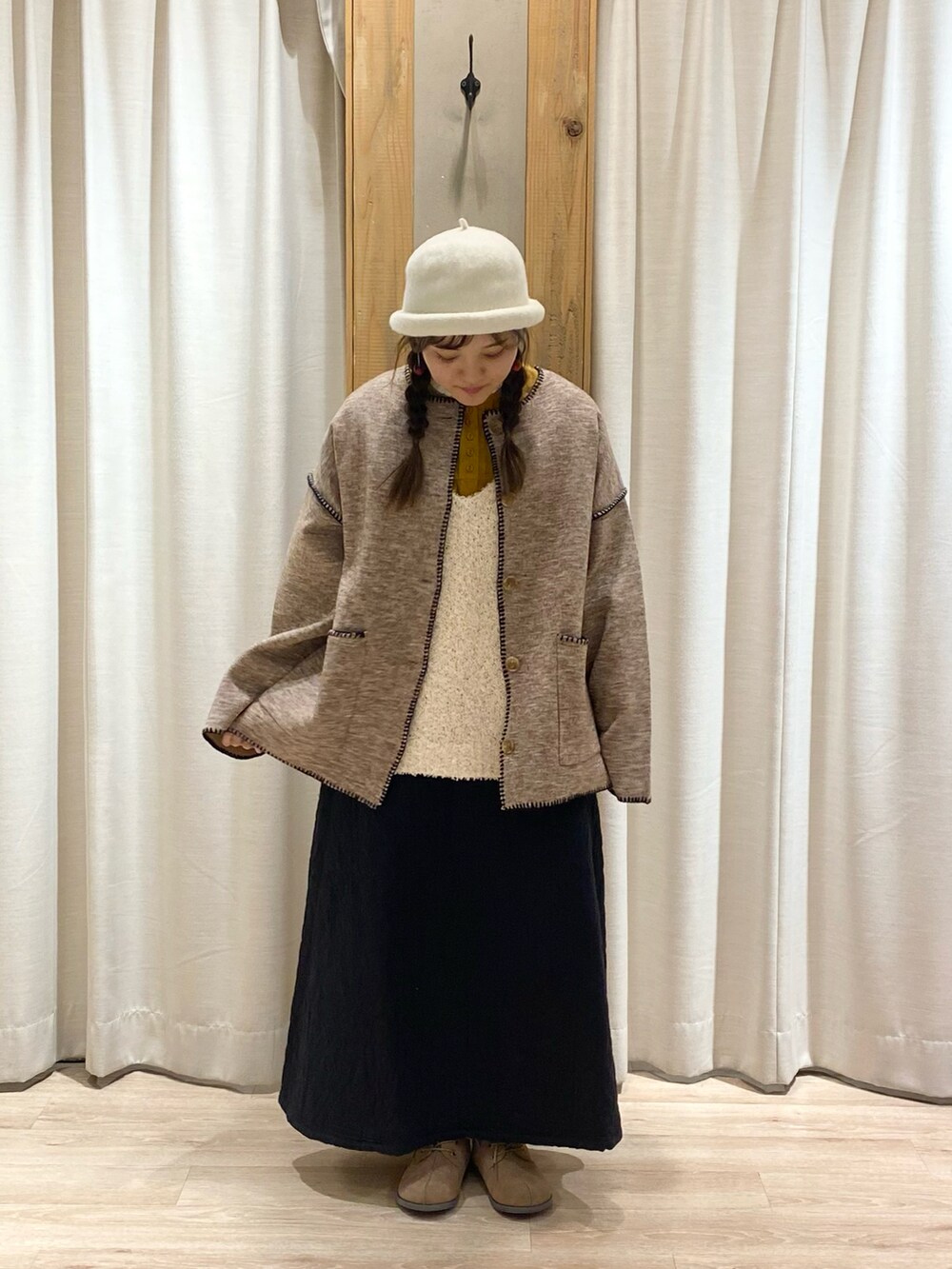 ベージュ系のノーカラージャケットを着用したレディースの冬コーディネートの3枚目の写真