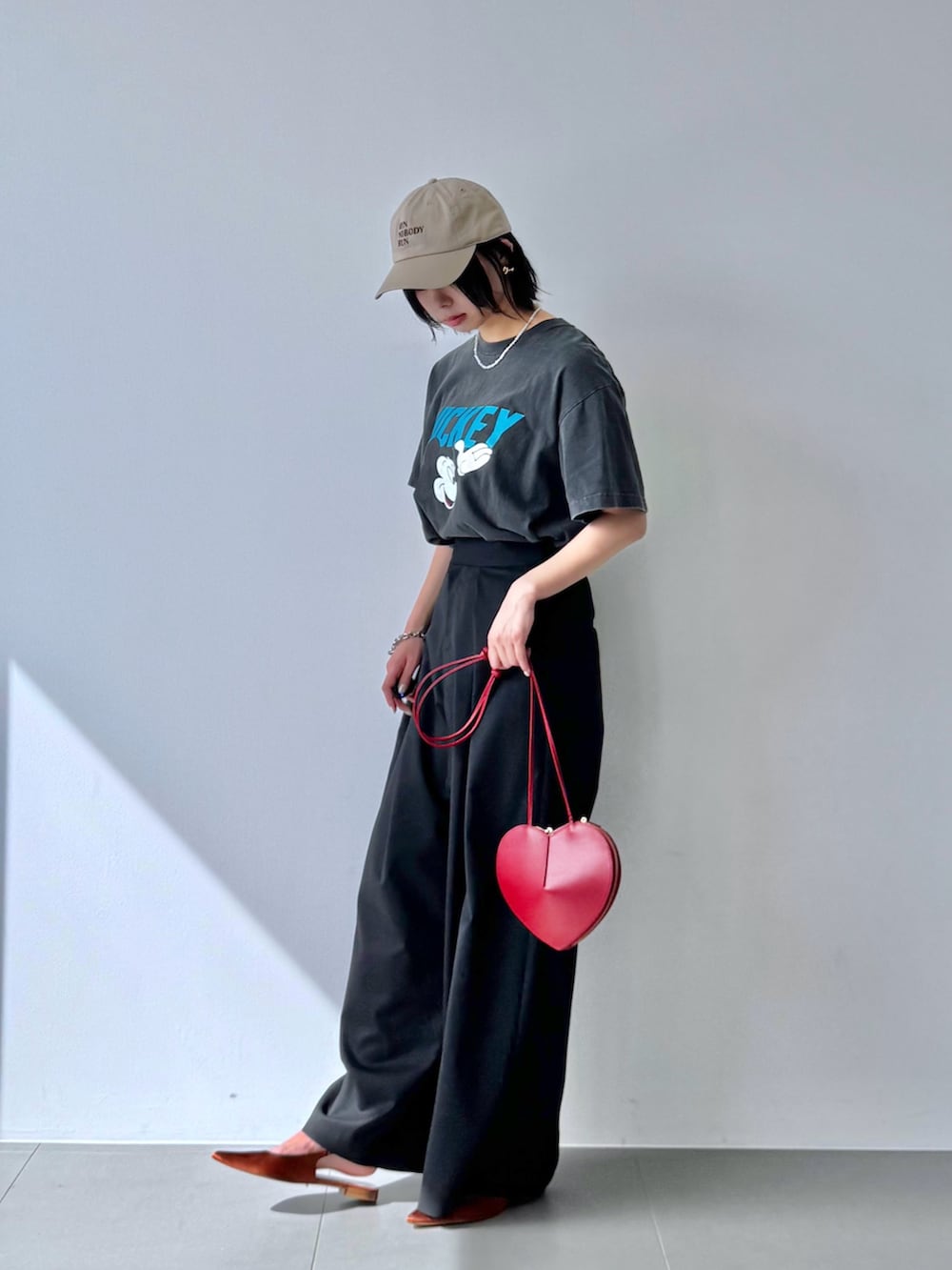 グレー系のTシャツ/カットソー、レッド系のショルダーバッグ、ブラウン系のパンプスを着用したレディースの春コーディネートの3枚目の写真
