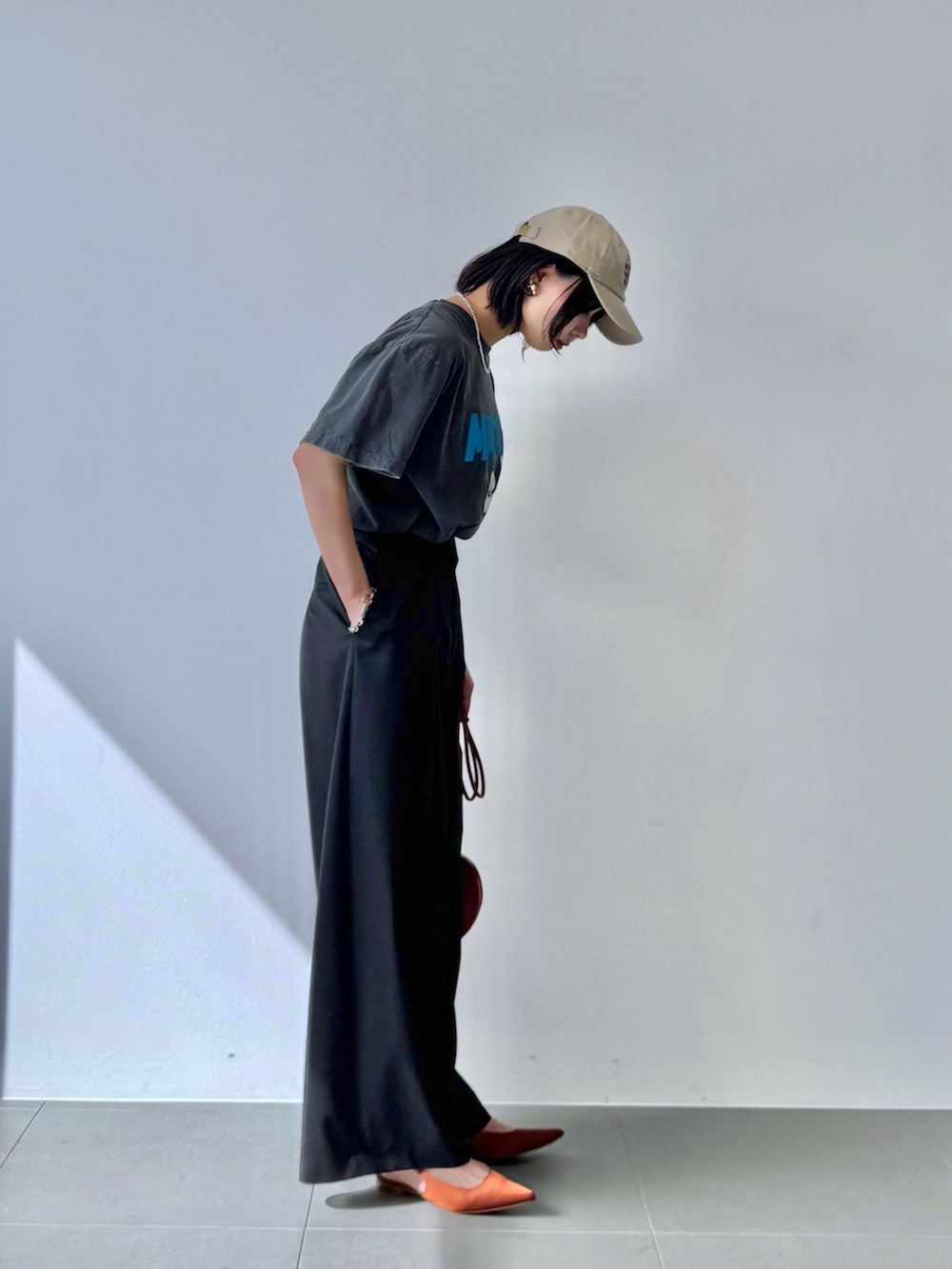 グレー系のTシャツ/カットソー、レッド系のショルダーバッグ、ブラウン系のパンプスを着用したレディースの春コーディネートの4枚目の写真