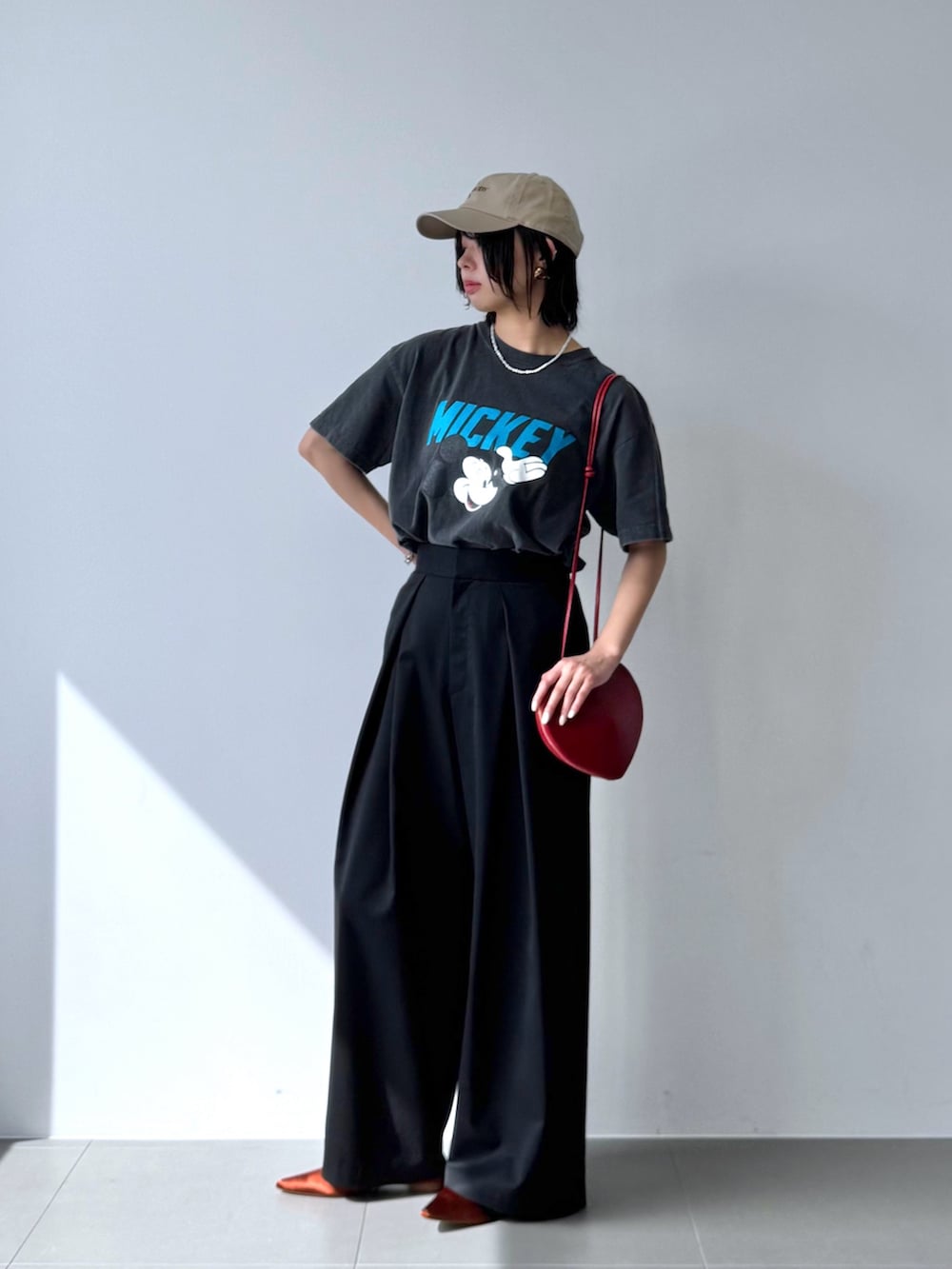 グレー系のTシャツ/カットソー、レッド系のショルダーバッグ、ブラウン系のパンプスを着用したレディースの春コーディネートの2枚目の写真