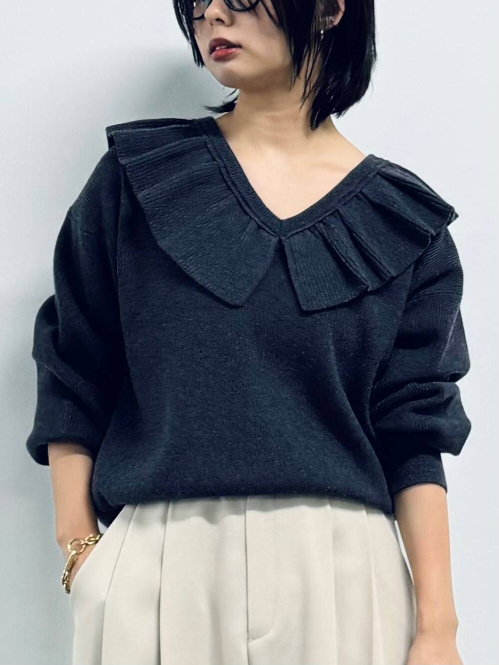 ブラック系のボストンバッグ、ブラック系のパンプス、グレー系のニット/セーターを着用したレディースの秋コーディネートの5枚目の写真