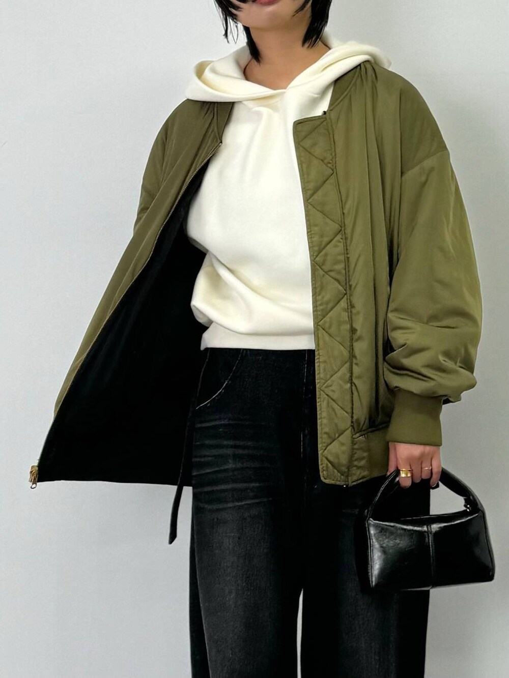 ブラック系のデニムパンツ、ブラック系のパンプス、ブラック系のMA-1を着用したレディースの秋コーディネートの6枚目の写真