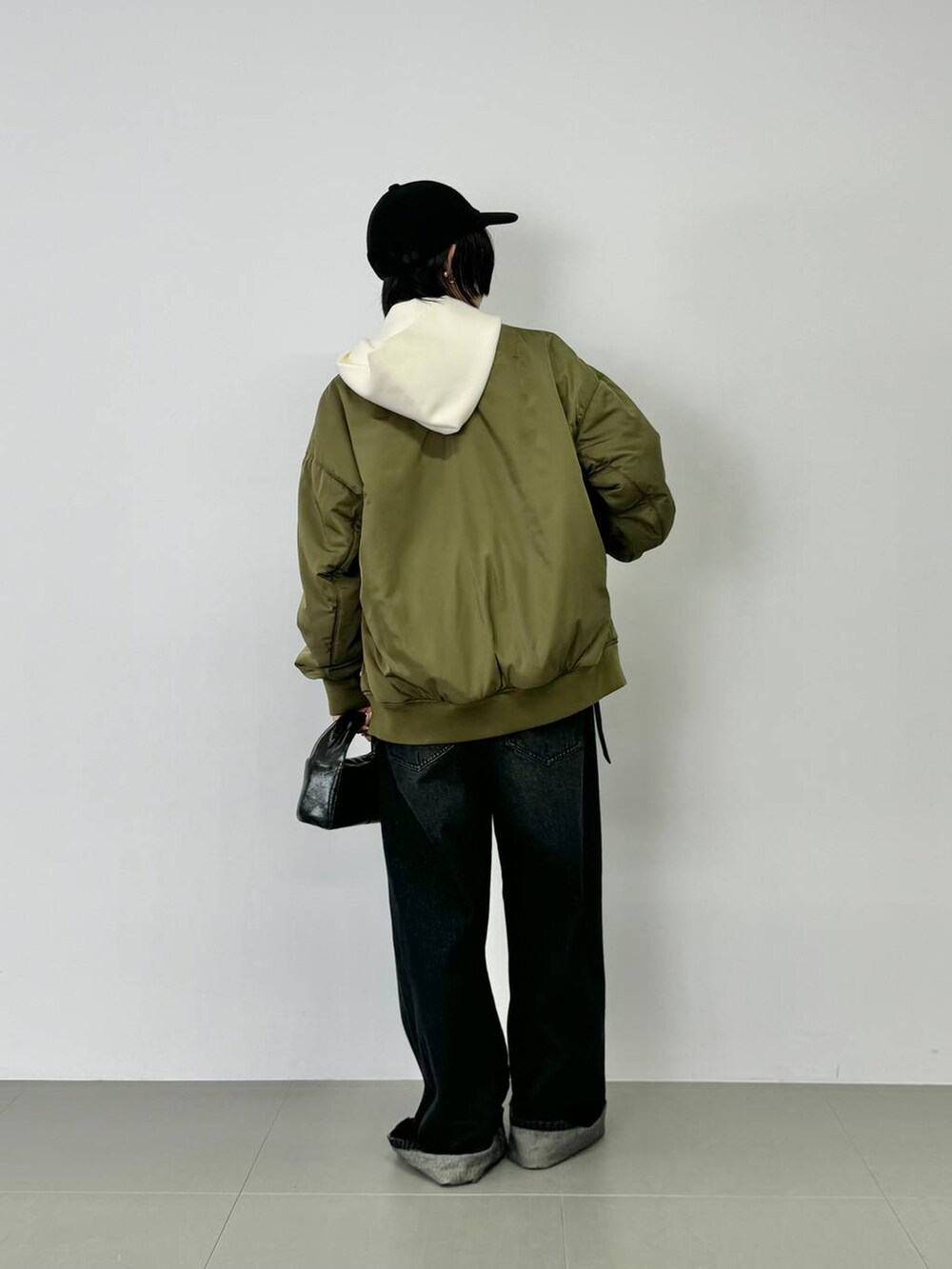 ブラック系のデニムパンツ、ブラック系のパンプス、ブラック系のMA-1を着用したレディースの秋コーディネートの4枚目の写真