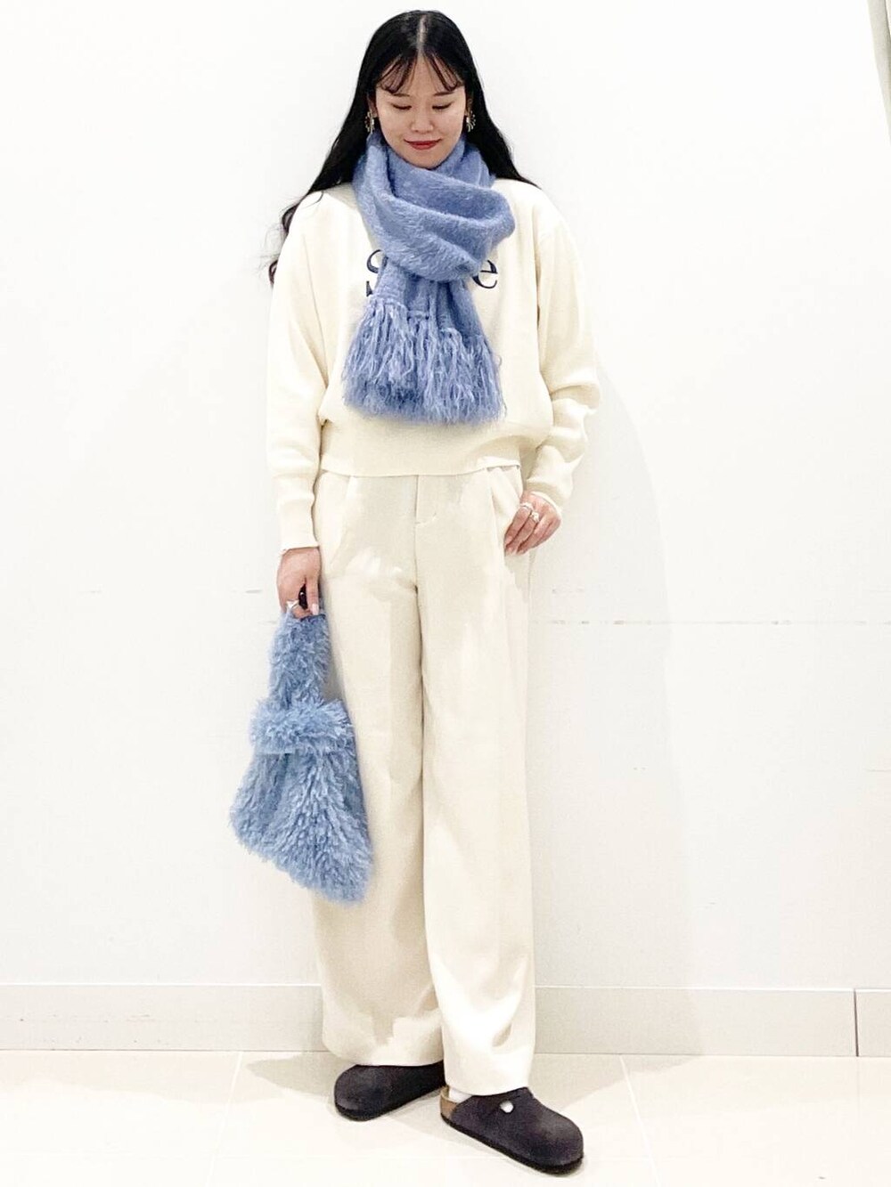 ブルー系のハンドバッグ、ホワイト系のその他パンツ、ホワイト系のニット/セーターを着用したレディースの冬コーディネートの6枚目の写真