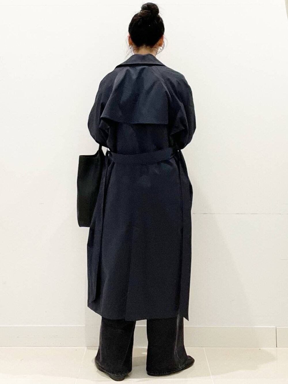 ブラック系のデニムパンツ、グレー系のニット/セーター、ブラック系のローファーを着用したレディースの春コーディネートの6枚目の写真