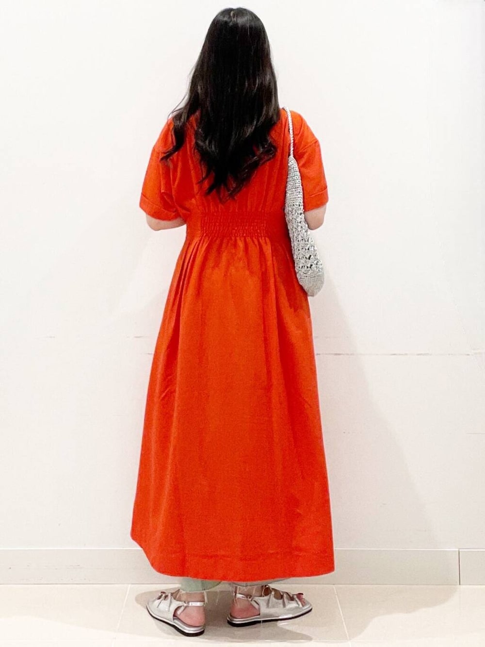 シルバー系のハンドバッグ、ホワイト系のキャミソール、レッド系のワンピースを着用したレディースの夏コーディネートの6枚目の写真