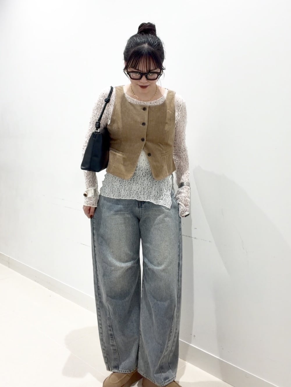 ホワイト系のTシャツ/カットソー、ベージュ系のダウンベスト、ホワイト系のキャミソールを着用したレディースの秋コーディネートの3枚目の写真