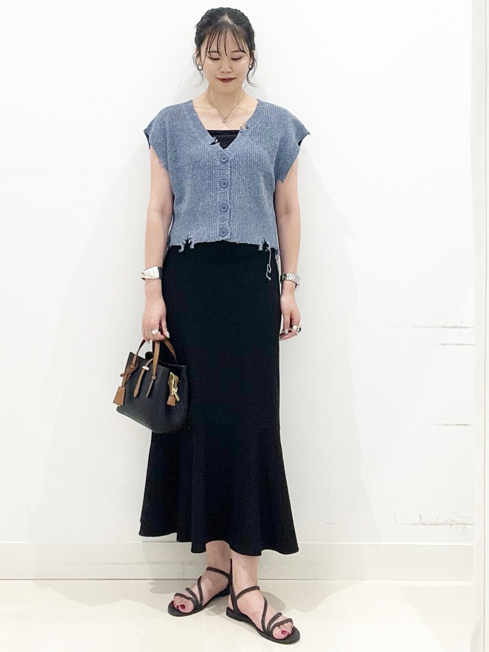 ブラック系のハンドバッグ、ブラック系のキャミソール、ブラック系のサンダルを着用したレディースの夏コーディネートの6枚目の写真