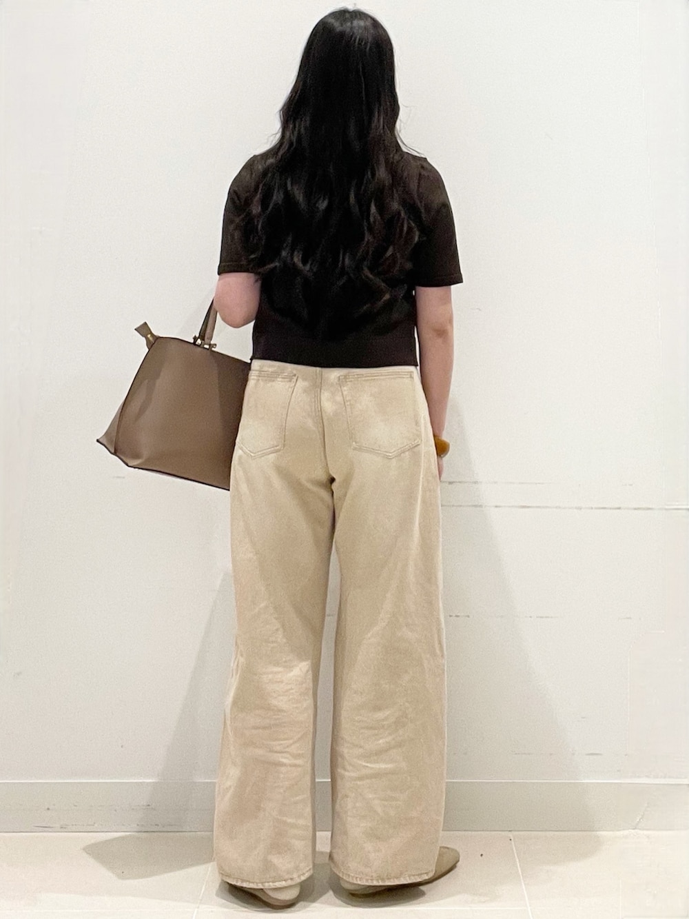 ブラウン系のカーディガン/ボレロ、ベージュ系のデニムパンツ、ブラウン系のビジネスバッグを着用したレディースの春コーディネートの5枚目の写真