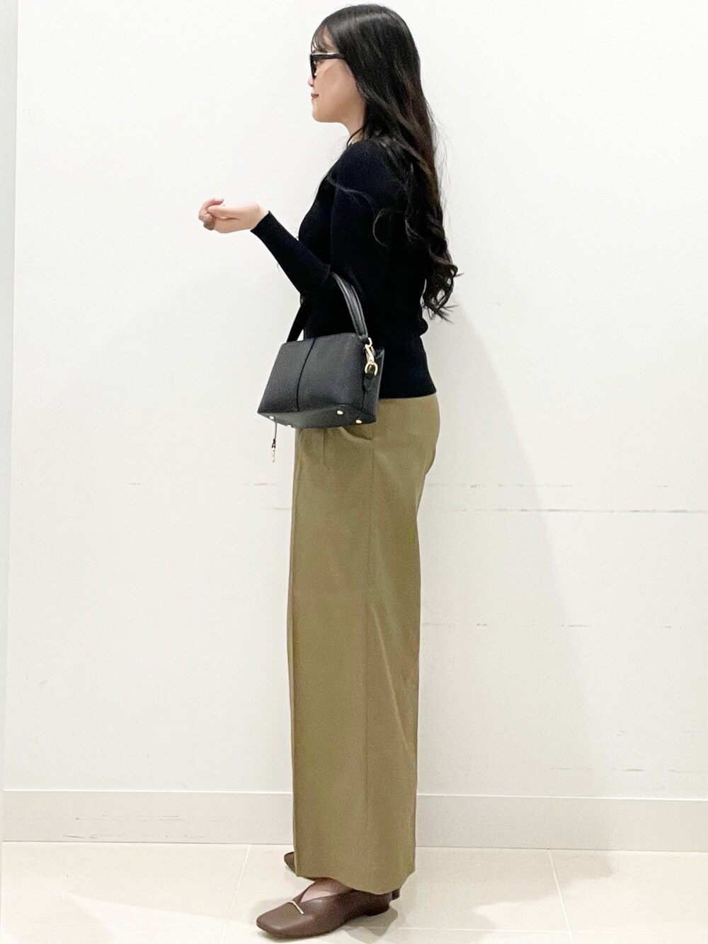 ブラウン系のその他シューズ、ベージュ系のその他パンツ、ブラック系のショルダーバッグを着用したレディースの冬コーディネートの6枚目の写真