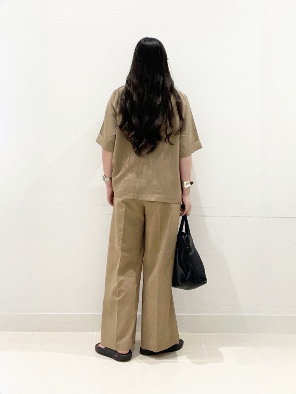 ベージュ系のテーラードジャケット、ホワイト系のTシャツ/カットソー、ベージュ系のスラックスを着用したレディースの夏コーディネートの3枚目の写真