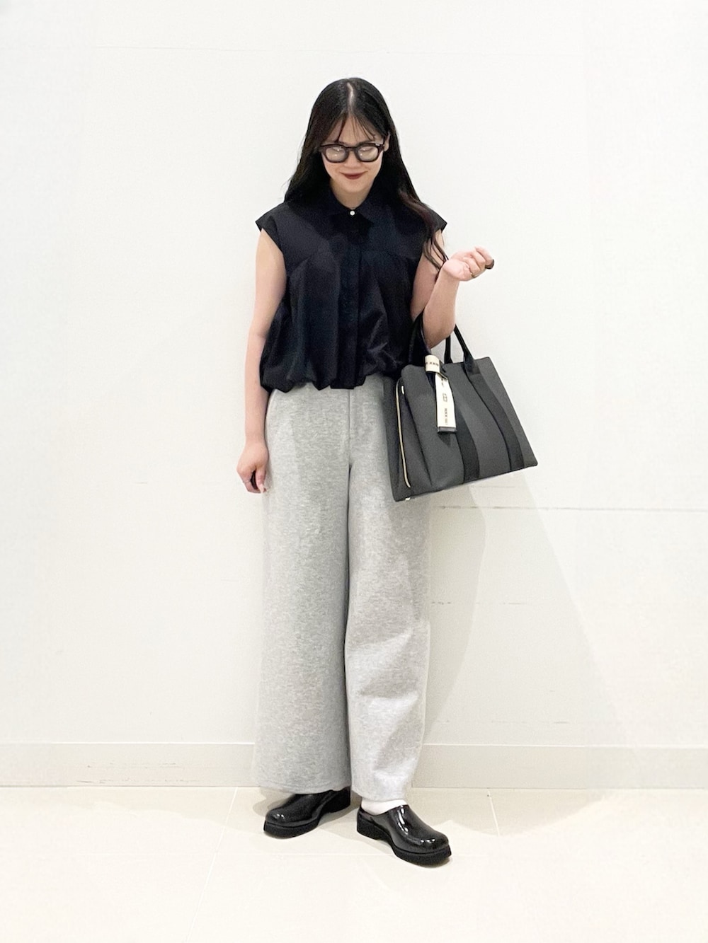 ブラック系のシャツ/ブラウス、グレー系のその他パンツ、ブラック系のサンダルを着用したレディースの夏コーディネートの3枚目の写真