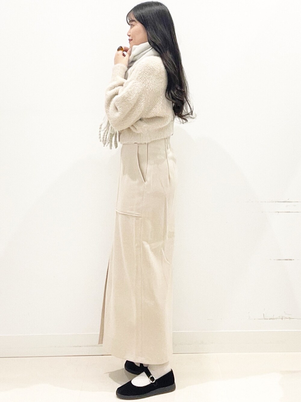 ブラック系のその他シューズ、ベージュ系のスカート、ベージュ系のハンドバッグを着用したレディースの秋コーディネートの7枚目の写真