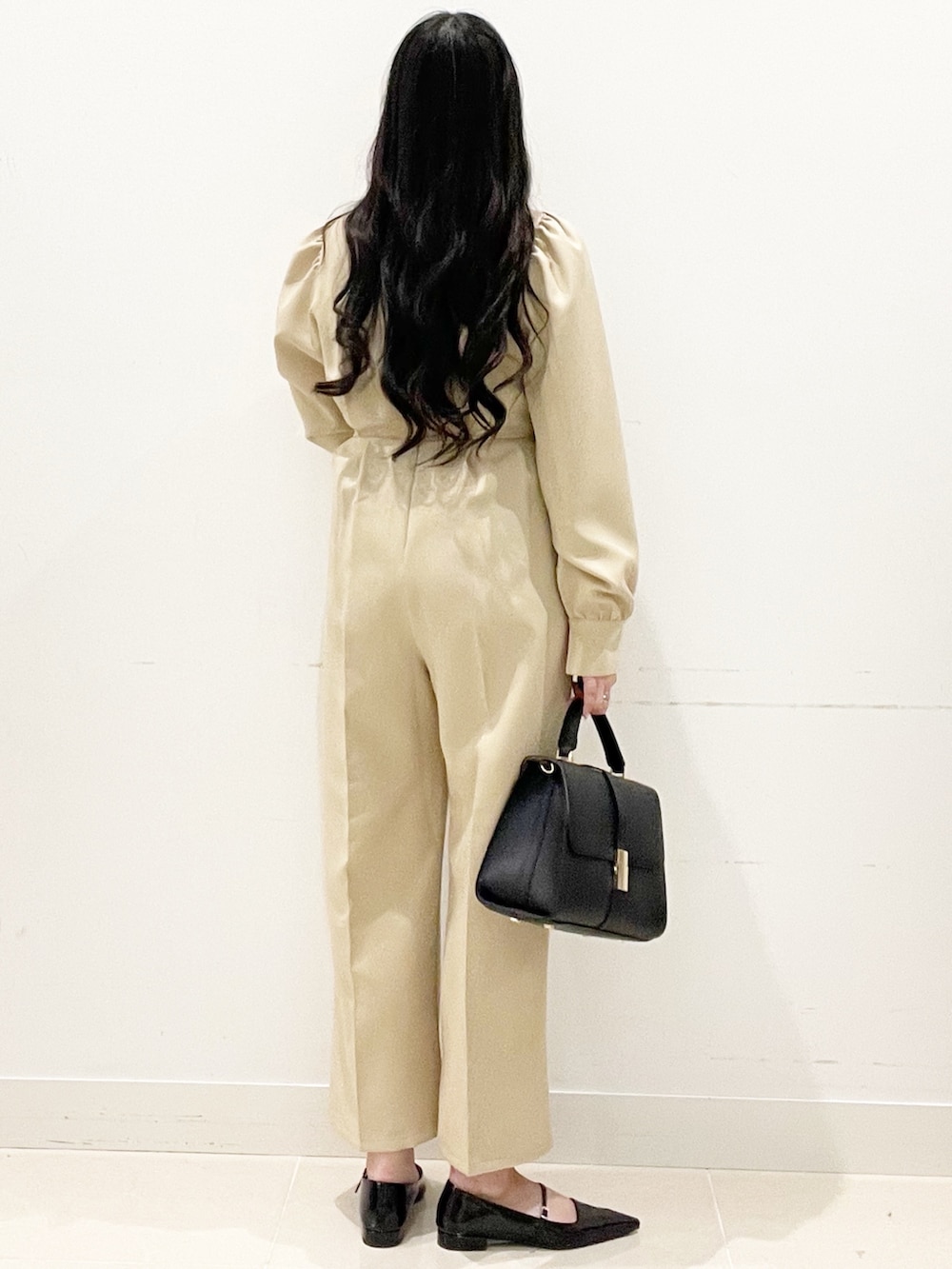 ブラック系のパンプス、ベージュ系のつなぎ/オールインワン、ブラック系のハンドバッグを着用したレディースの冬コーディネートの5枚目の写真