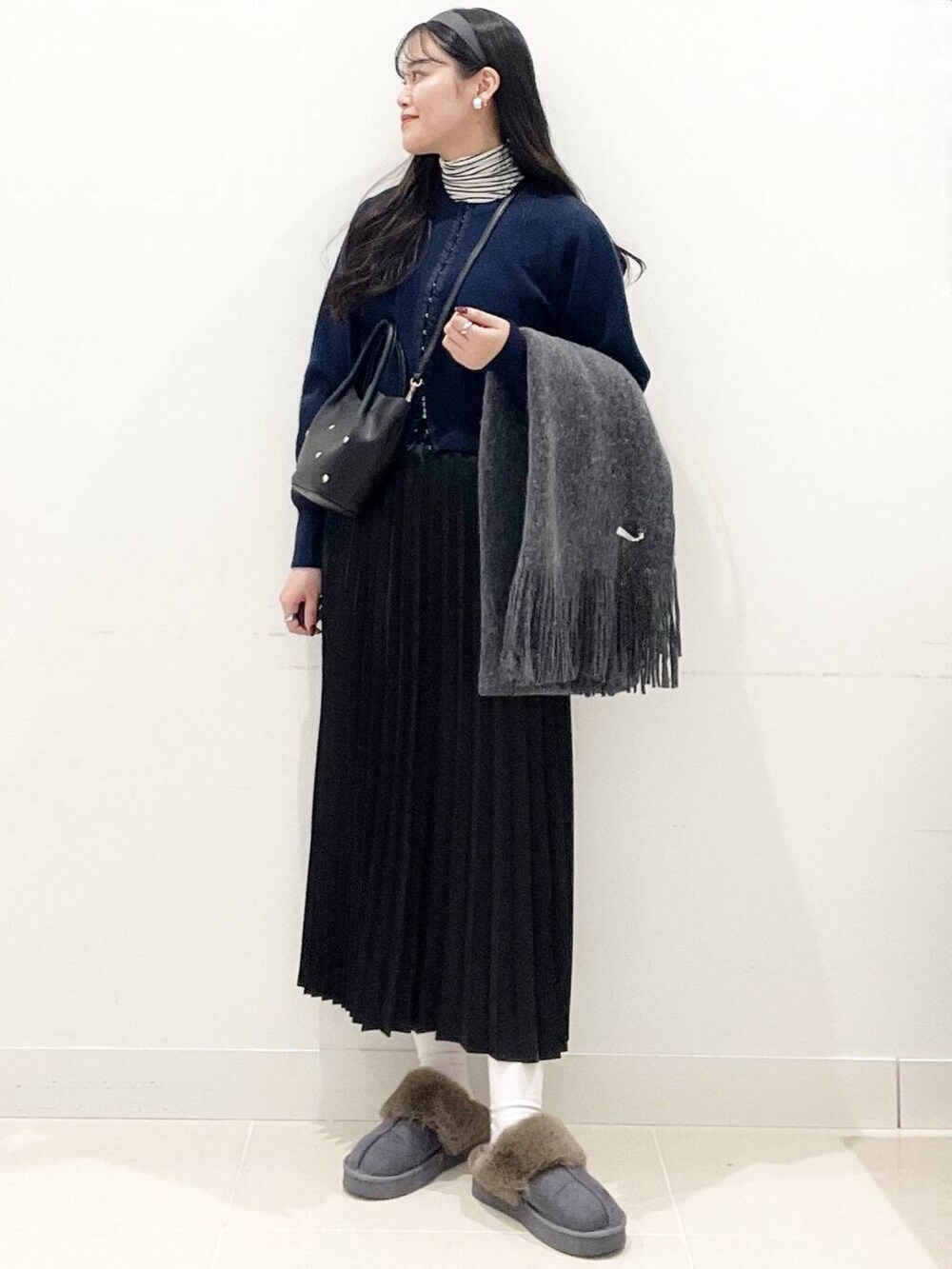 ホワイト系のTシャツ/カットソー、ブルー系のカーディガン/ボレロ、ブラック系のショルダーバッグを着用したレディースの冬コーディネートの4枚目の写真