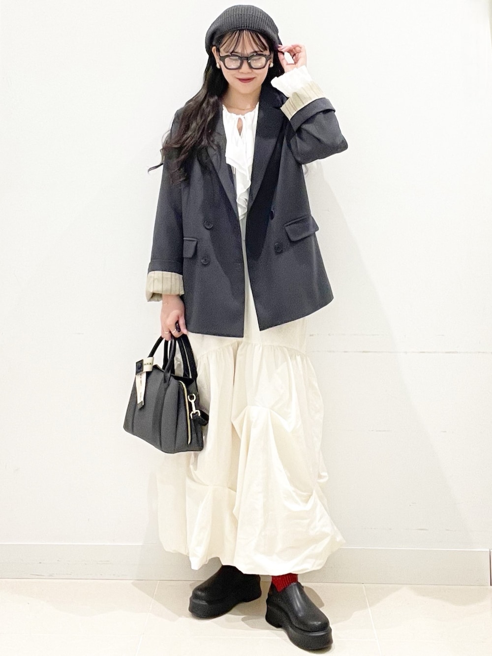 ブラック系のその他シューズ、ブラック系のハンドバッグ、ホワイト系のスカートを着用したレディースの冬コーディネートの4枚目の写真