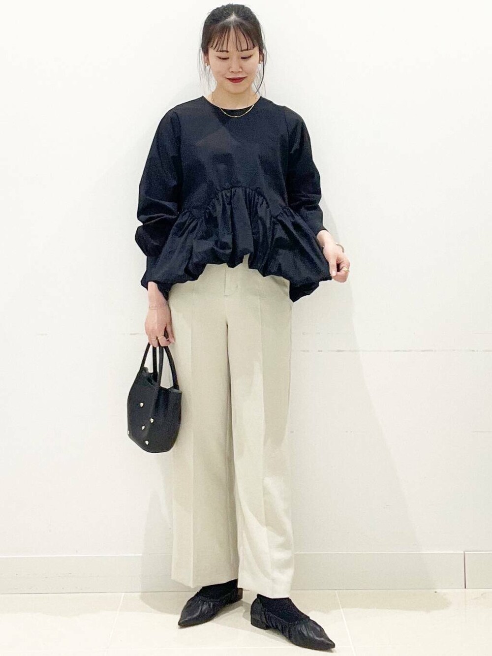 ブラック系のショルダーバッグ、ブラック系のバレエシューズ、ベージュ系のその他パンツを着用したレディースの春コーディネートの3枚目の写真