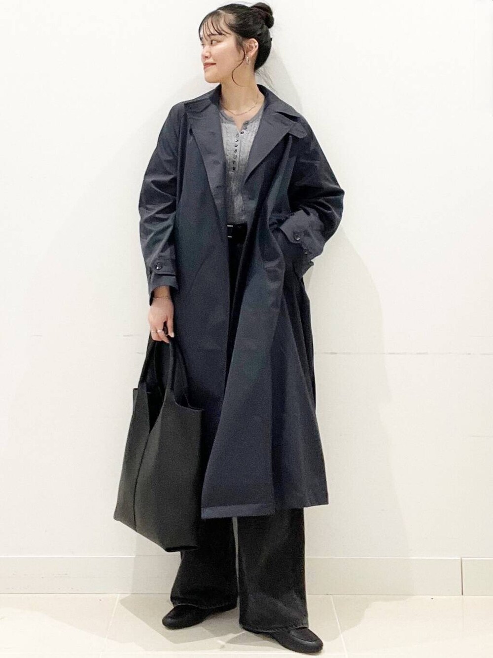 ブラック系のデニムパンツ、グレー系のニット/セーター、ブラック系のローファーを着用したレディースの春コーディネートの2枚目の写真