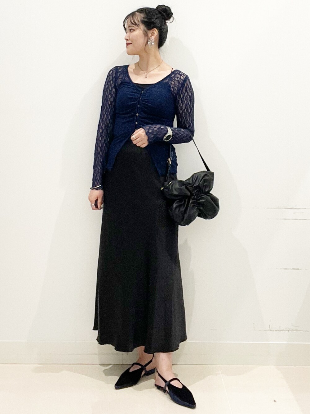 ブラック系のキャミソール、ブラック系のハンドバッグ、ブルー系のパンプスを着用したレディースの秋コーディネートの2枚目の写真