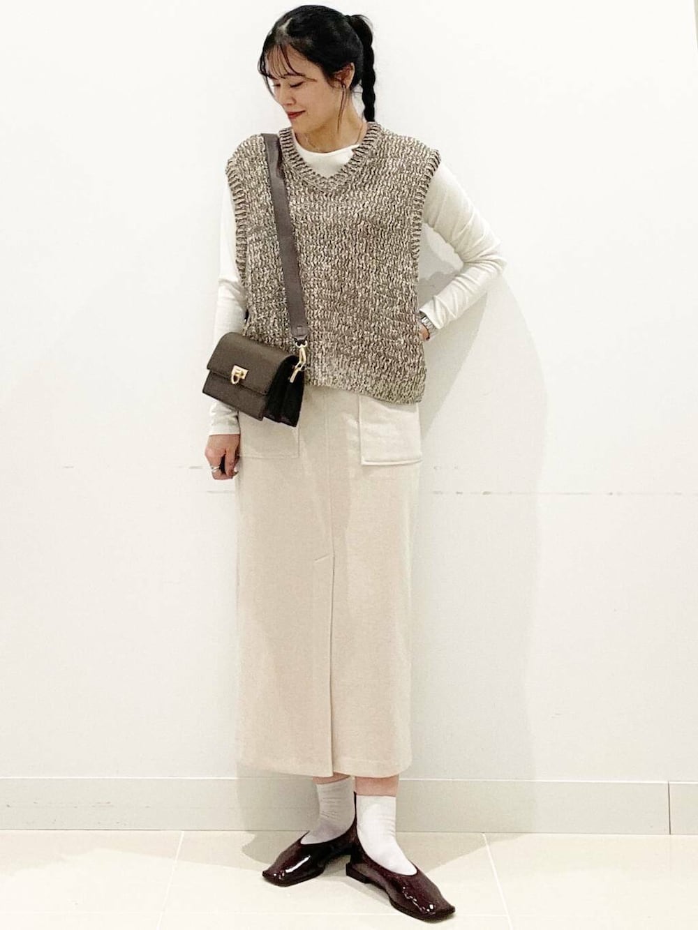 ブラウン系のショルダーバッグ、レッド系のバレエシューズ、ホワイト系のTシャツ/カットソーを着用したレディースの秋コーディネートの4枚目の写真