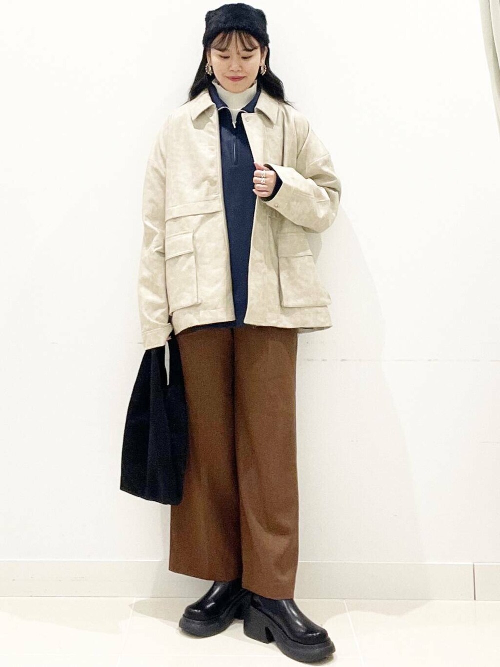 ブルー系のスウェット、ホワイト系のニット/セーター、ブラック系のトートバッグを着用したレディースの秋コーディネートの2枚目の写真