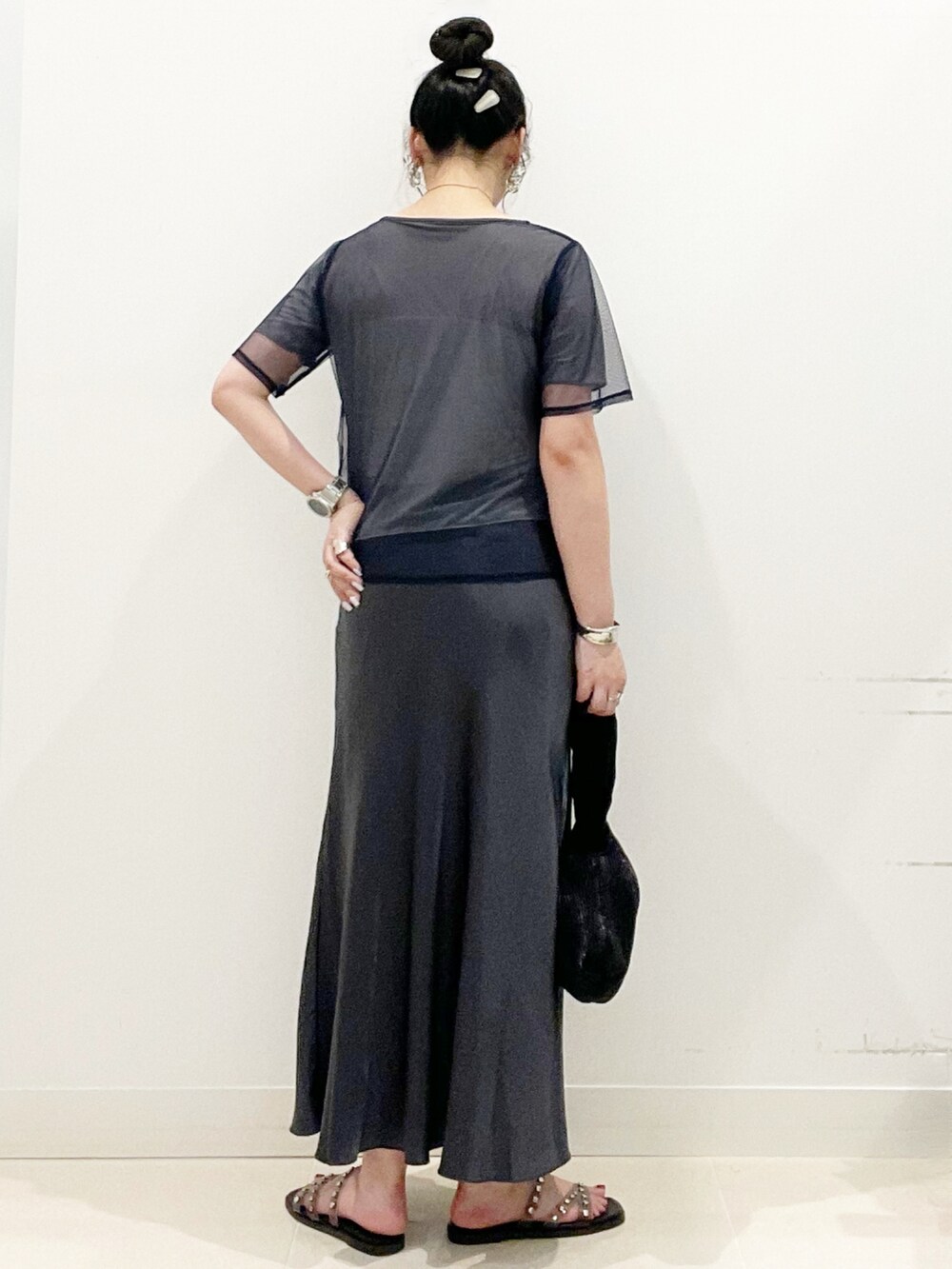 ブラック系のサンダル、ゴールド系のハンドバッグ、ブルー系のTシャツ/カットソーを着用したレディースの夏コーディネートの6枚目の写真