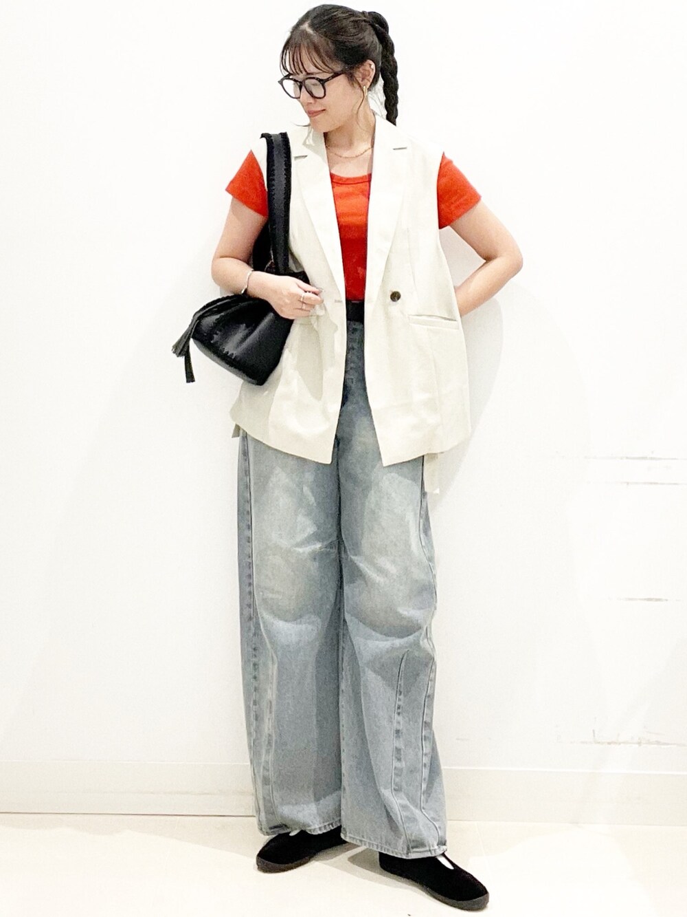 ベージュ系のベスト、レッド系のTシャツ/カットソー、ブルー系のデニムパンツを着用したレディースの夏コーディネートの4枚目の写真