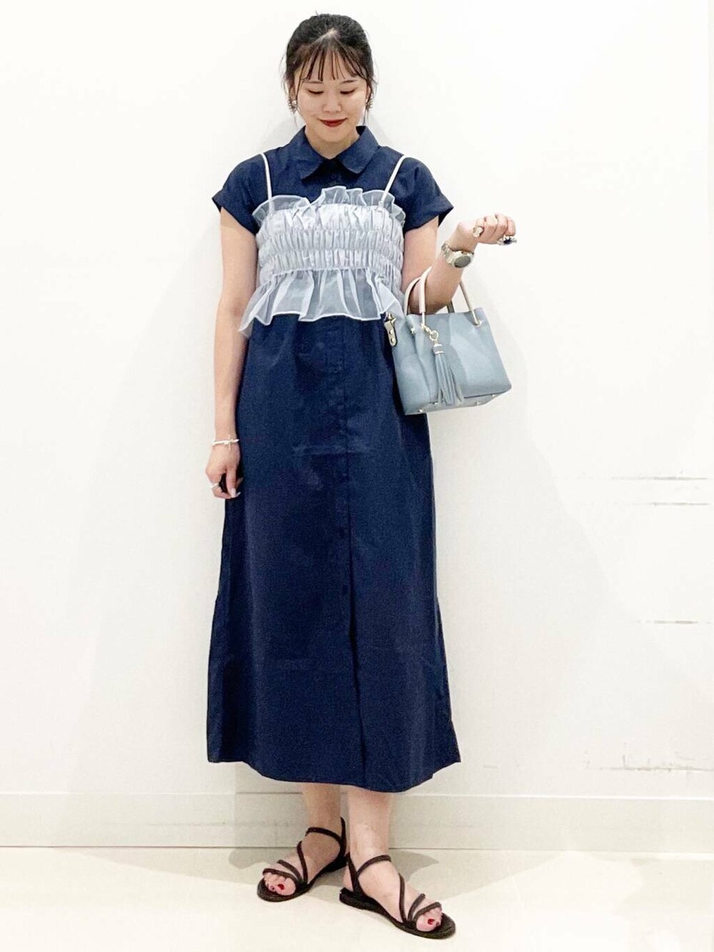 ブルー系のトートバッグ、ブラック系のサンダル、ブルー系のワンピースを着用したレディースの夏コーディネートの5枚目の写真