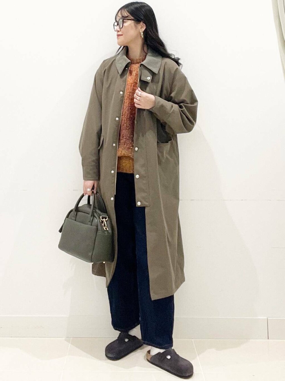 グリーン系のボストンバッグ、ブルー系のデニムパンツ、ブラウン系のその他アウターを着用したレディースの秋コーディネートの3枚目の写真