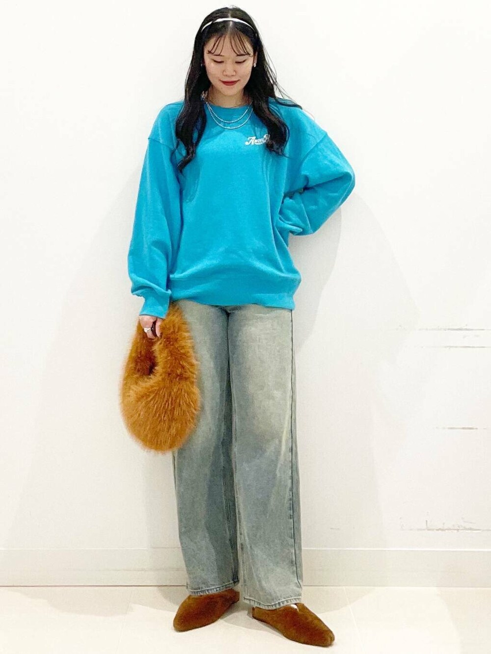 ブラウン系のハンドバッグ、イエロー系のその他シューズ、ブルー系のデニムパンツを着用したレディースの秋コーディネートの4枚目の写真