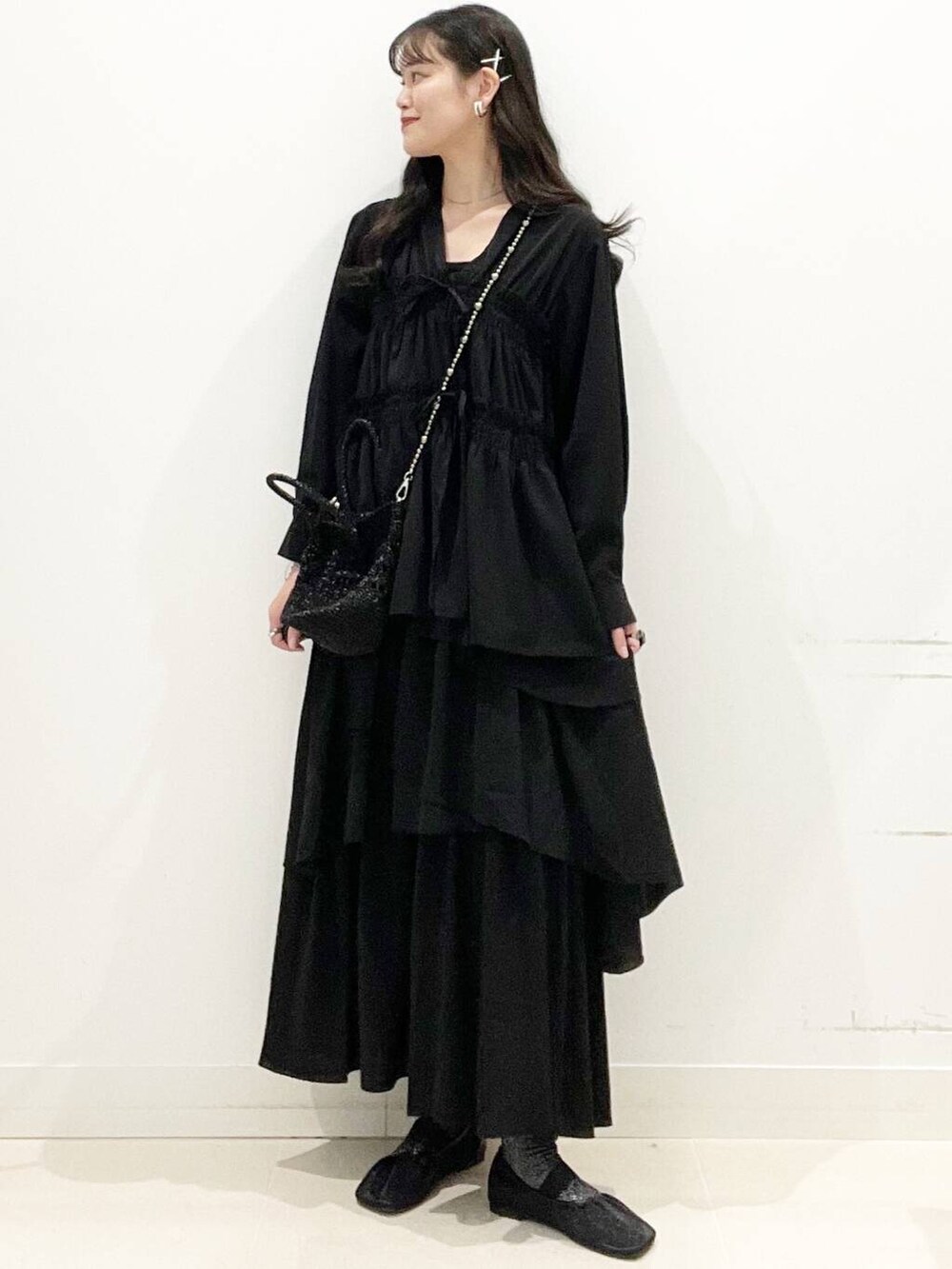 ブラック系のショルダーバッグ、ブラック系のキャミソール、ブラック系のパンプスを着用したレディースの春コーディネートの2枚目の写真