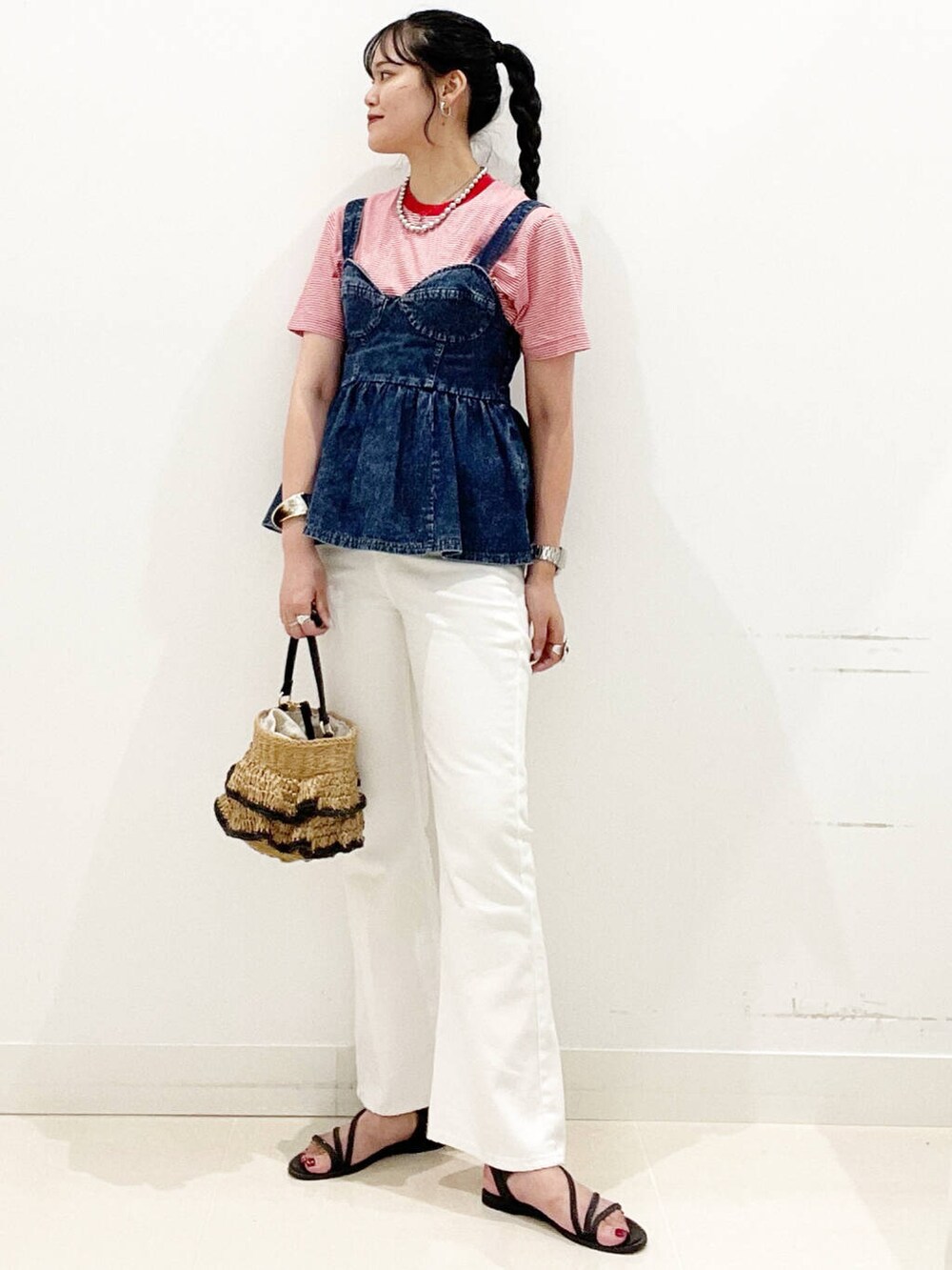 ホワイト系のデニムパンツ、ブラック系のサンダル、ブルー系のベストを着用したレディースの夏コーディネートの3枚目の写真