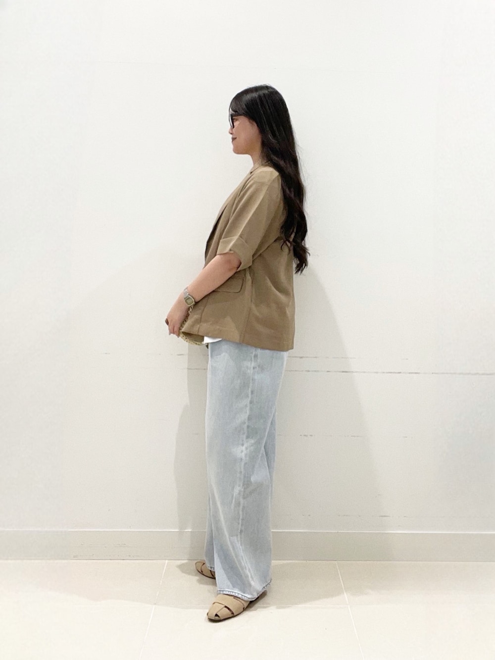 ベージュ系のテーラードジャケット、ホワイト系のTシャツ/カットソー、ブルー系のデニムパンツを着用したレディースの夏コーディネートの4枚目の写真