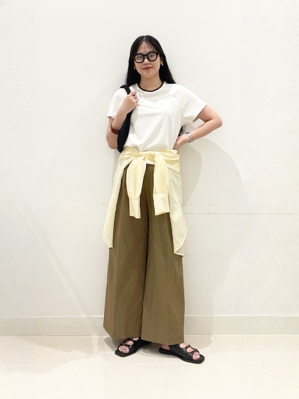 ベージュ系のチノパンツ、ブラック系のサンダル、イエロー系のシャツ/ブラウスを着用したレディースの夏コーディネートの4枚目の写真
