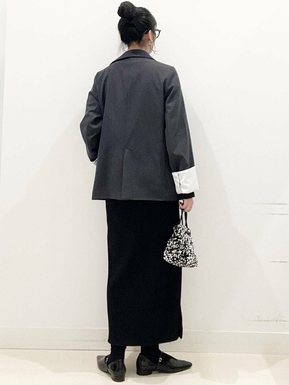 シルバー系のショルダーバッグ、グレー系のテーラードジャケット、ブラック系のパンプスを着用したレディースの冬コーディネートの7枚目の写真