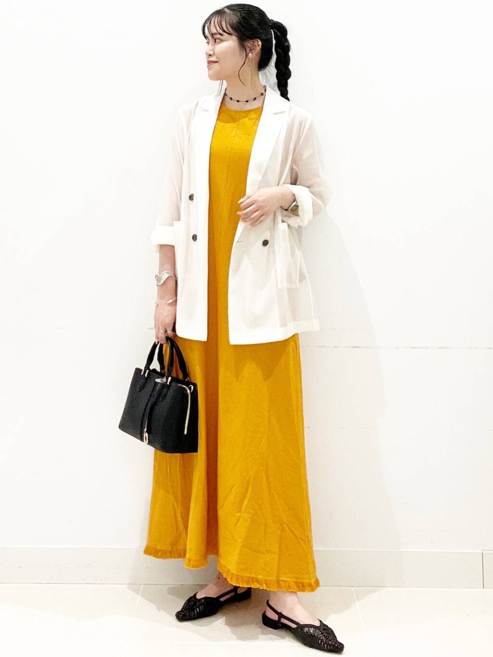 ブラック系のハンドバッグ、ブラック系のサンダル、ホワイト系のその他アウターを着用したレディースの夏コーディネートの3枚目の写真