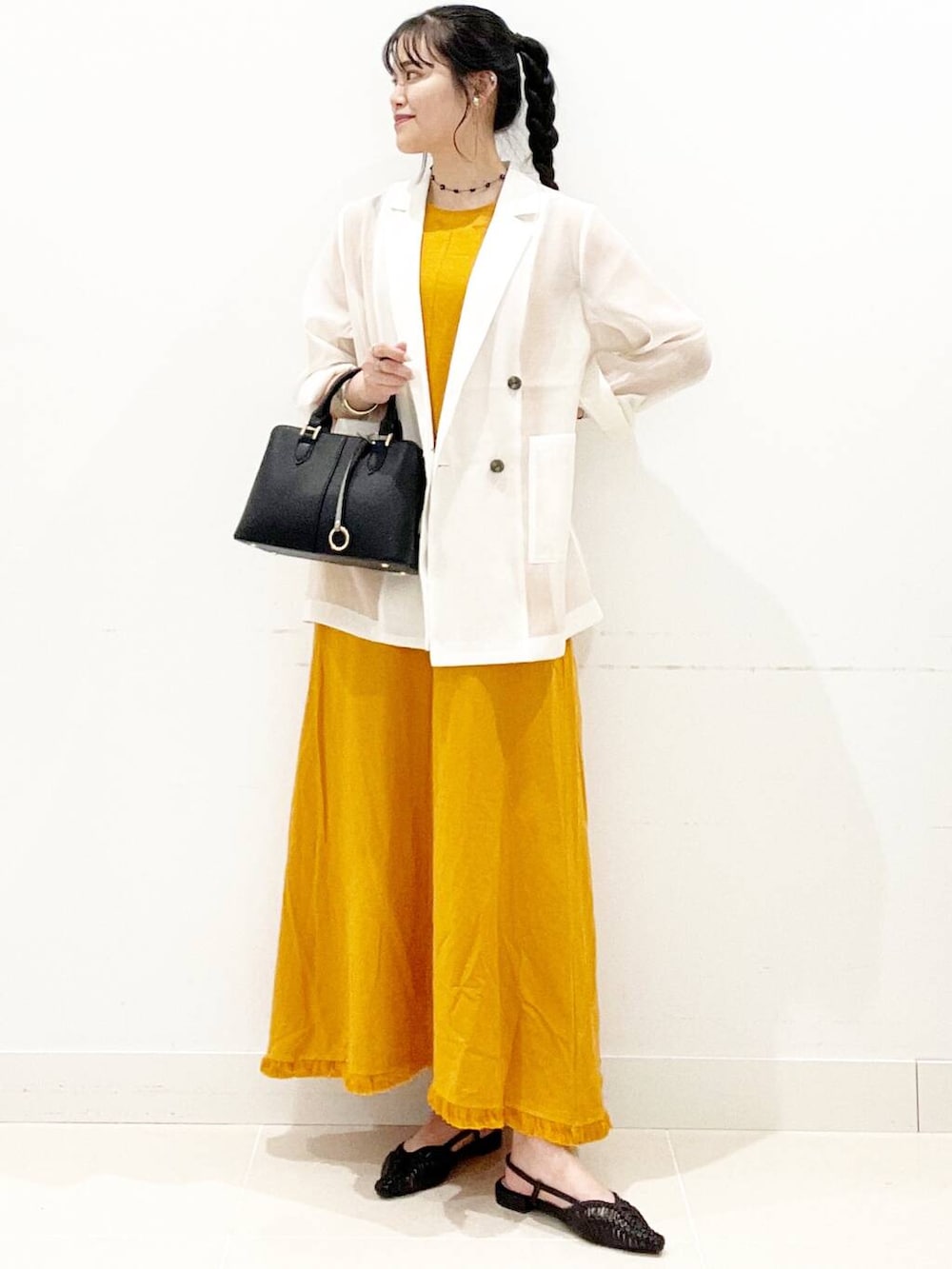 ブラック系のハンドバッグ、ブラック系のサンダル、ホワイト系のその他アウターを着用したレディースの夏コーディネートの2枚目の写真