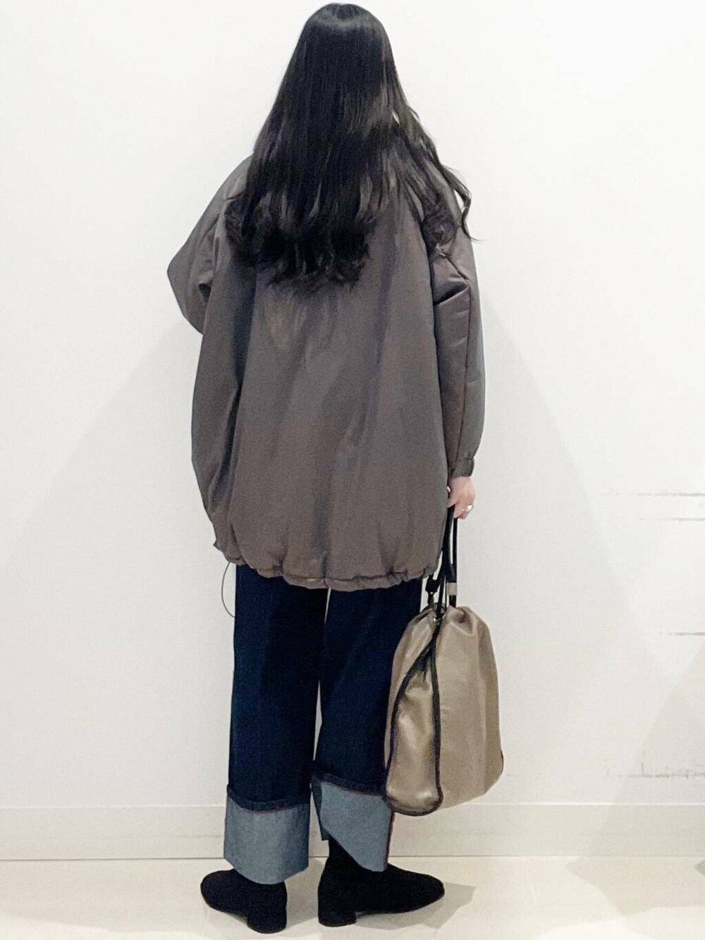 ブラック系のブーツ、レッド系のニット/セーター、ブルー系のデニムパンツを着用したレディースの冬コーディネートの6枚目の写真