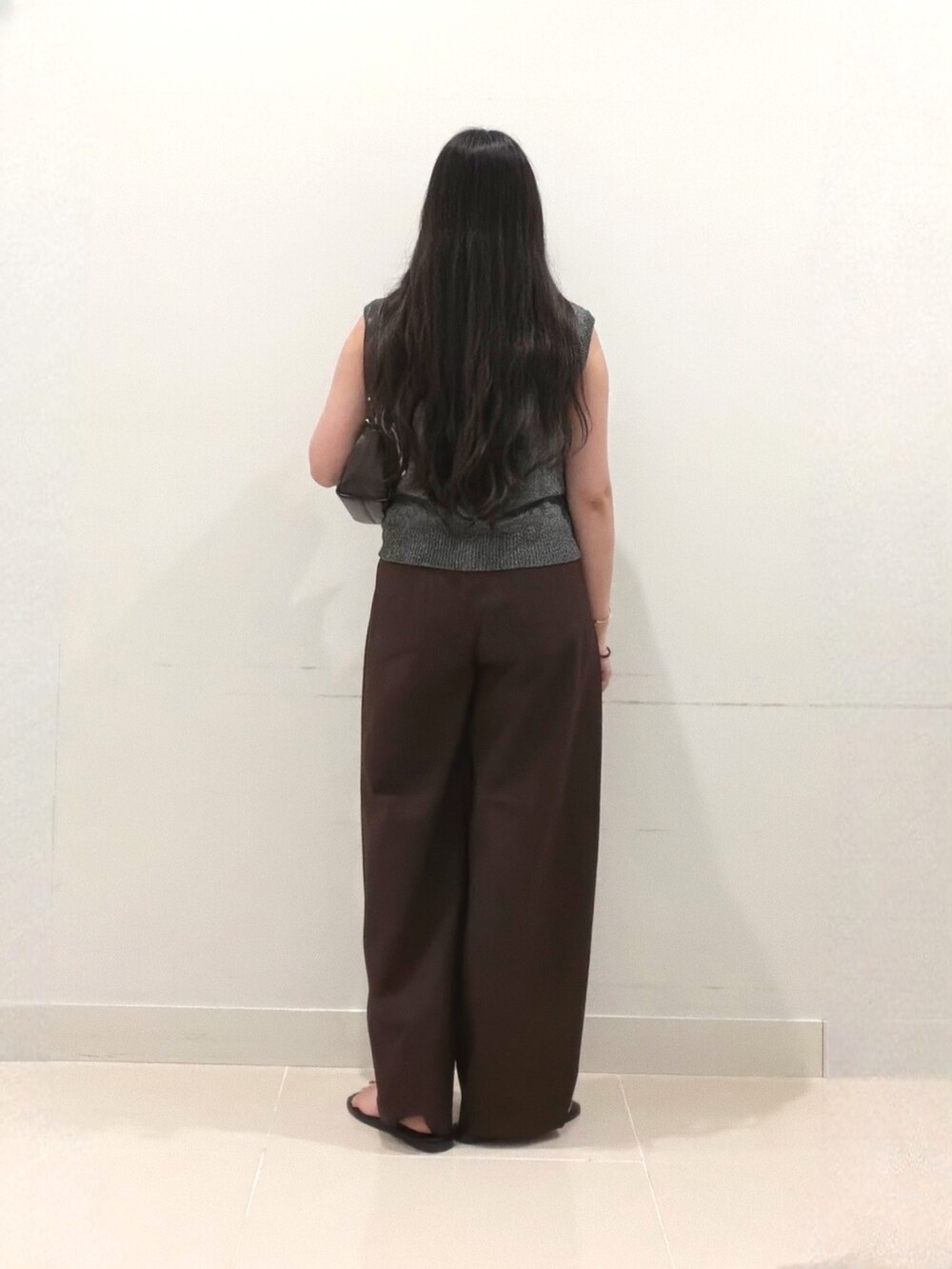 ブラック系のベスト、ブラウン系のその他パンツ、ブラウン系のショルダーバッグを着用したレディースの秋コーディネートの4枚目の写真